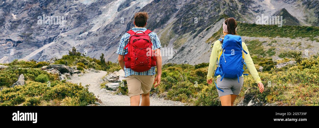 Wanderer wandern mit Campingrucksäcken Wandern von hinten mit Taschen auf Outdoor-Trekking in der Sommernatur. Neuseeland Reise Tramping Paar auf Hooker Stockfoto