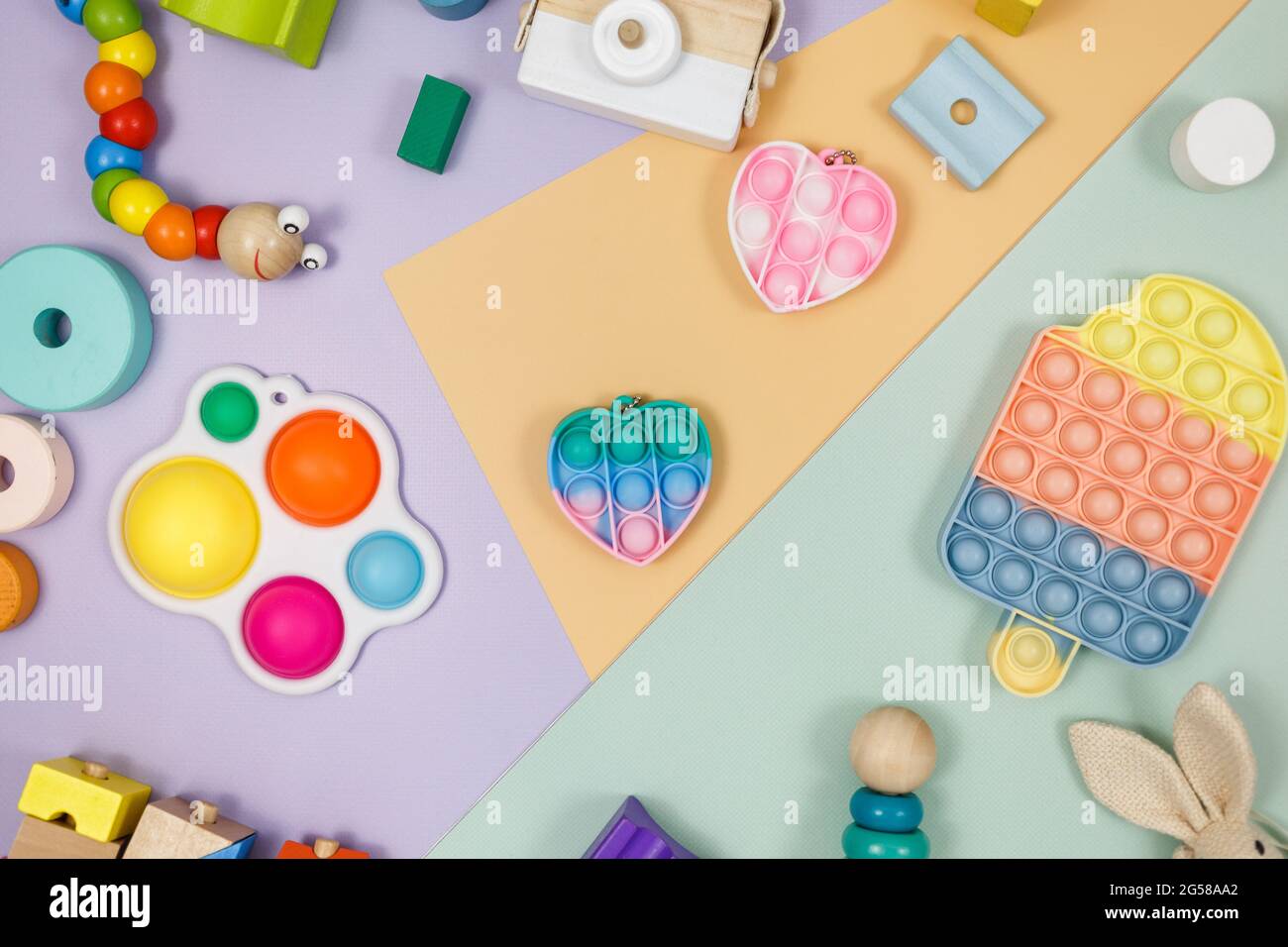 Beliebte Silikon-Anti-Stress-Pop-it-Spielzeug für ein Kind auf violett-grünem Hintergrund. Trendiges Reliever Stress Sensory Fidget Spielzeug. Stockfoto