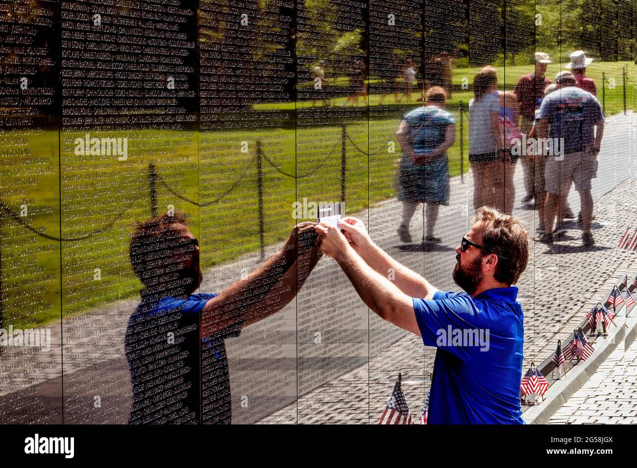 Der Besucher des Vietnam war Memorial in Washington D.C. hat einen Namen von der Mauer Stockfoto