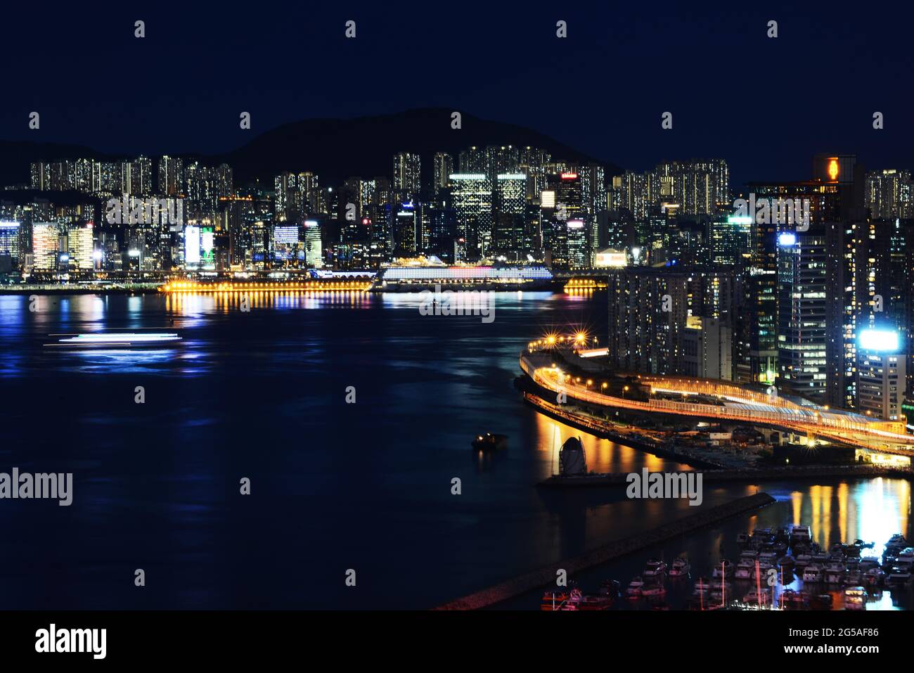 Nachtansicht des Victoria Hafens mit Kwun Tong im Hintergrund. Stockfoto