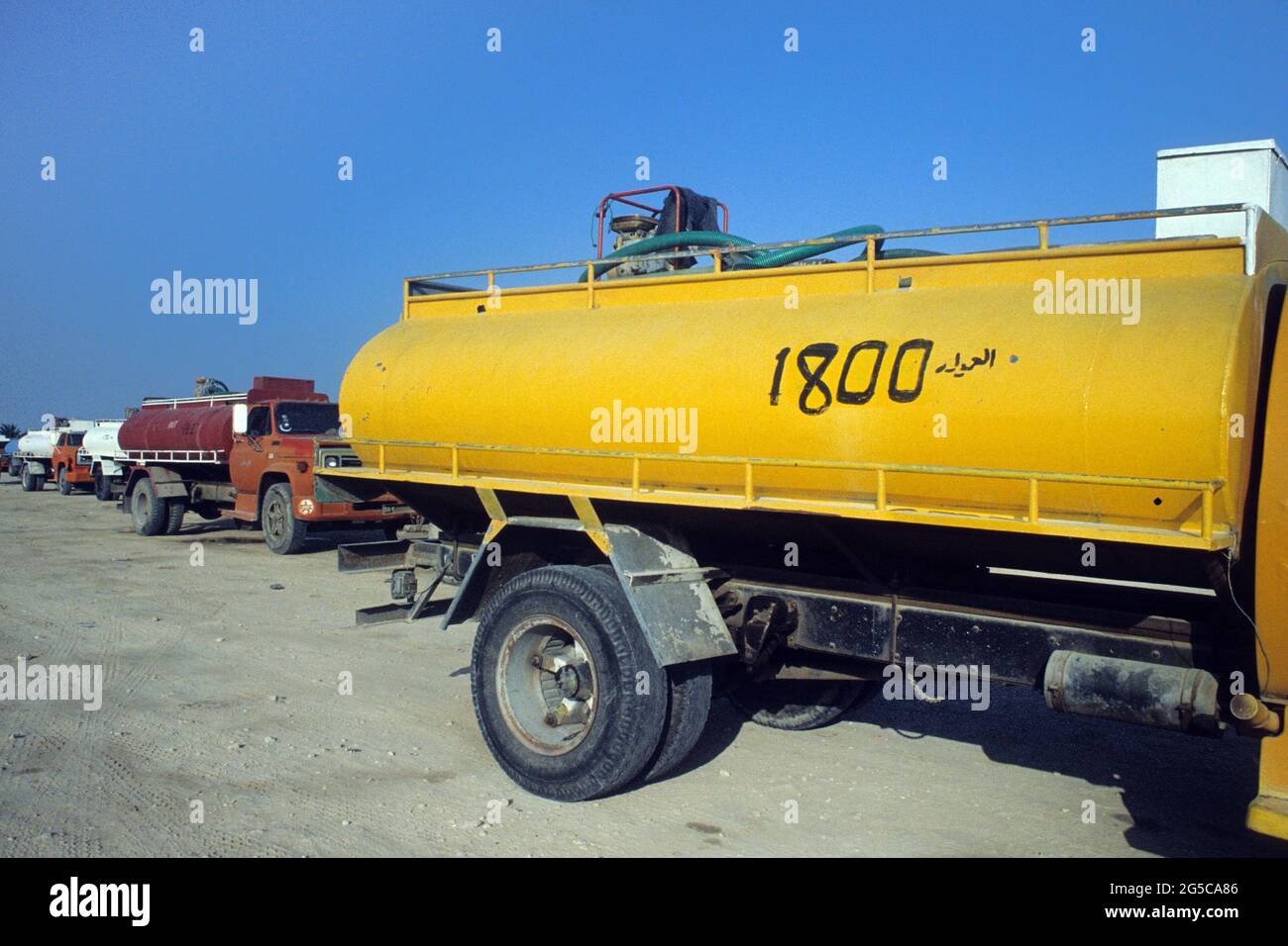 In der Stadt Doha warten mehrere LKWs auf das Auffüllen von Wasser an der Tankstelle. Sie verteilen Wasser an einzelne Gebäude. Diafild aus dem Jahr 1991 aufgenommen und gescannt. Stockfoto