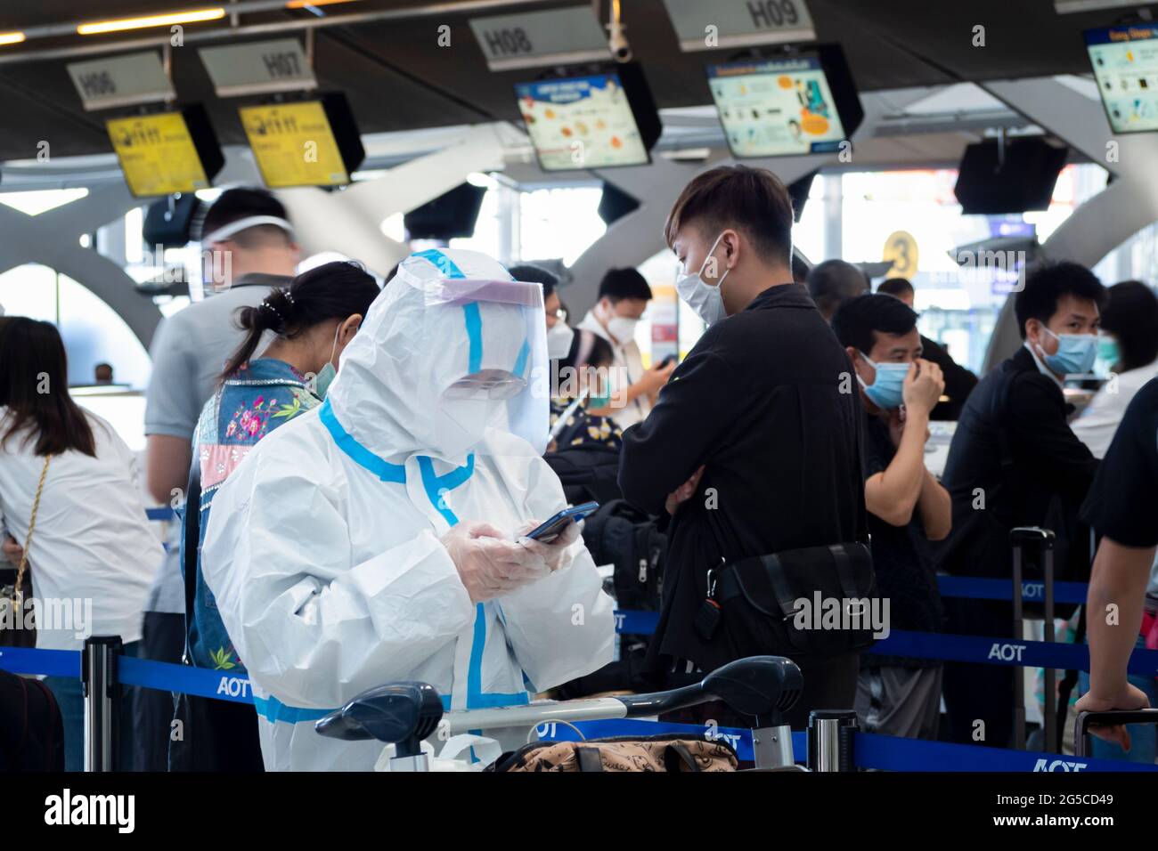 Bangkok, Thailand - 29. Juni 2021 : Asiatische Passagiere, die einen PSA-Anzug zum Schutz vor Covid-19 oder Coronavirus tragen, um vor dem Flug am Flughafen einzuchecken. Stockfoto