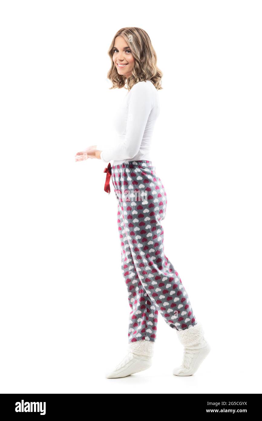 Schöne junge Frau im Pyjama einladend und einladende Geste am Eingang zu Hause. Ganzkörperlänge isoliert auf weißem Hintergrund. Stockfoto