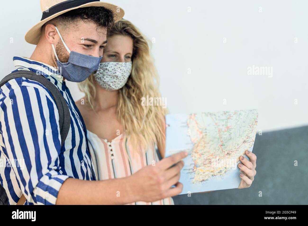 Reise junges Paar mit Stadtplan während einer Reise, während sie Gesichtsmaske trägt, um Corona-Virus zu verhindern Stockfoto Reise junges Paar mit Stadtplan während einer Reise, während sie Gesichtsmaske trägt, um Corona-Virus zu verhindern Stockfoto