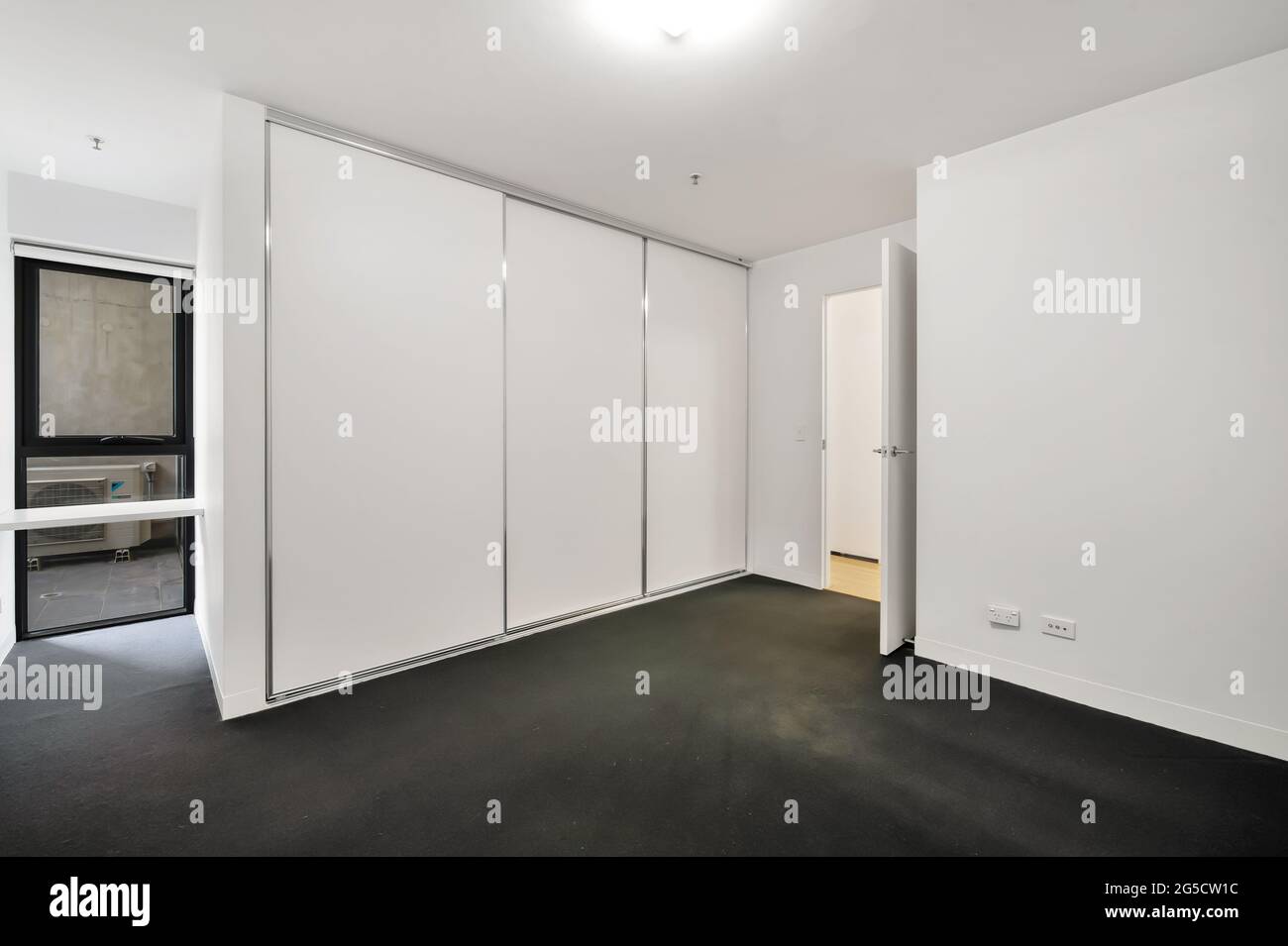 Leeres Schlafzimmer mit weißen Wänden und einem Kleiderschrank Stockfoto
