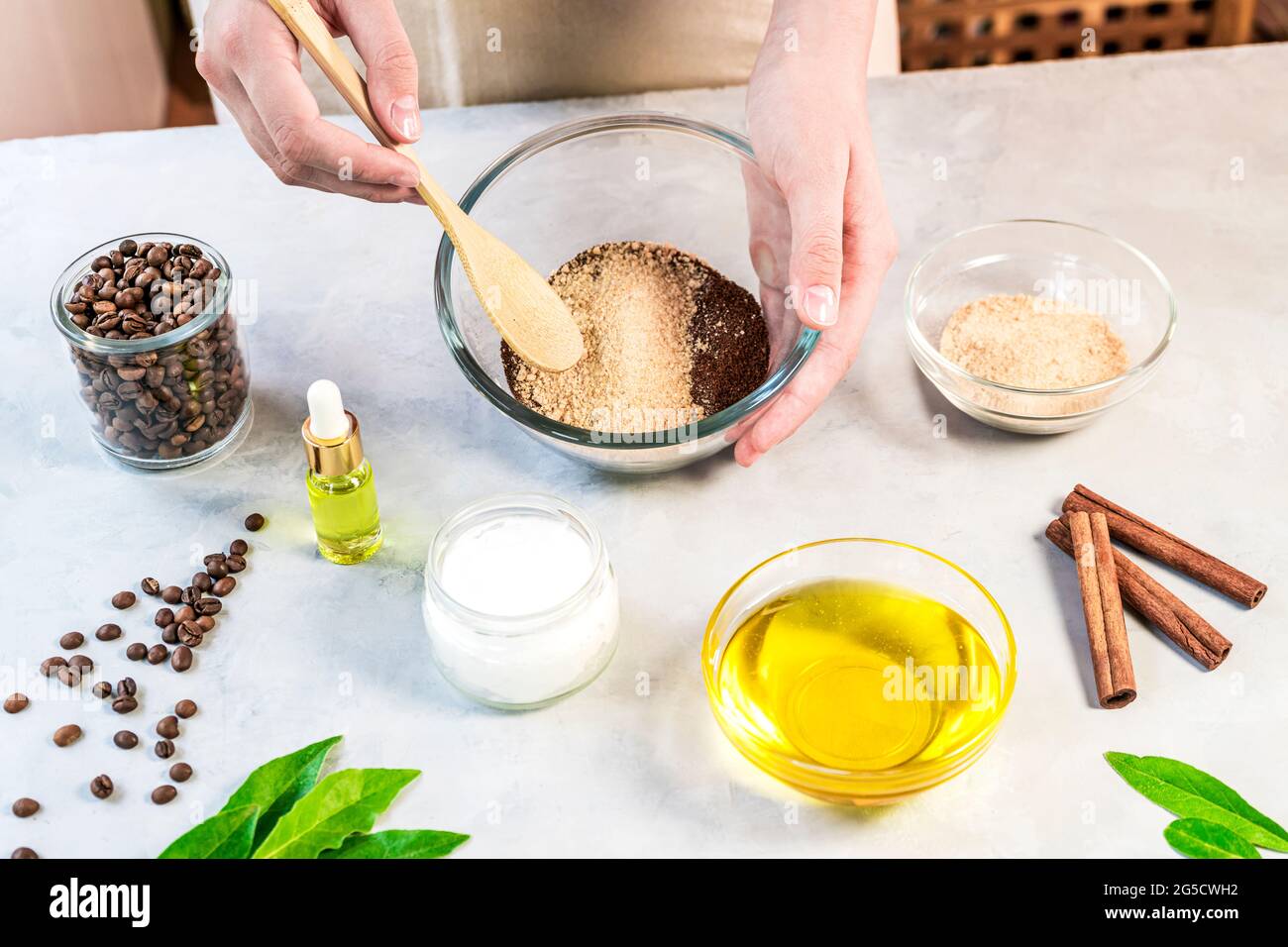 Frau, die Zutaten für die Zubereitung von Kaffee-Peeling oder Maske für die Hautbehandlung mischt Stockfoto