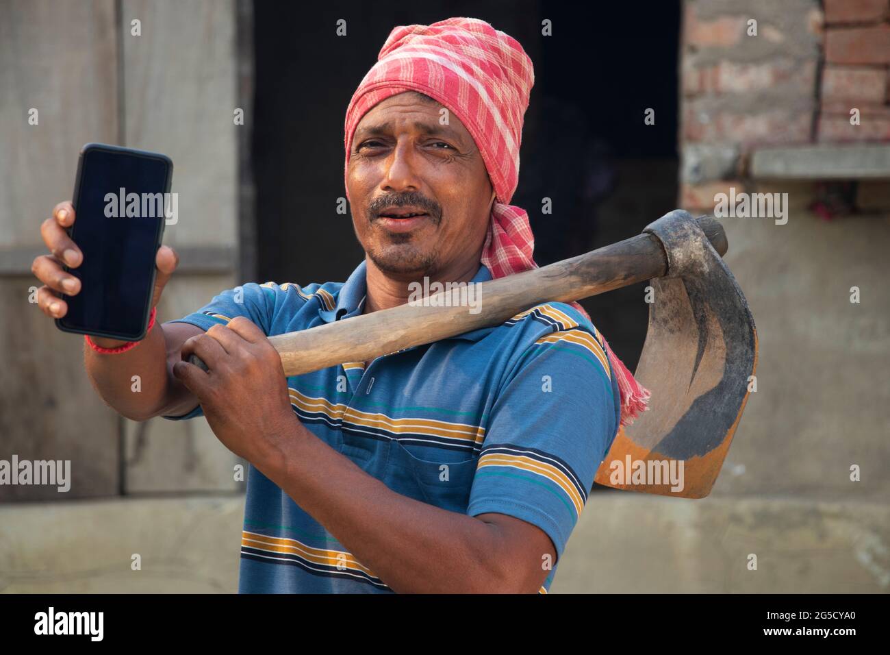 Rural Indian man zeigt auf Handy Stockfoto