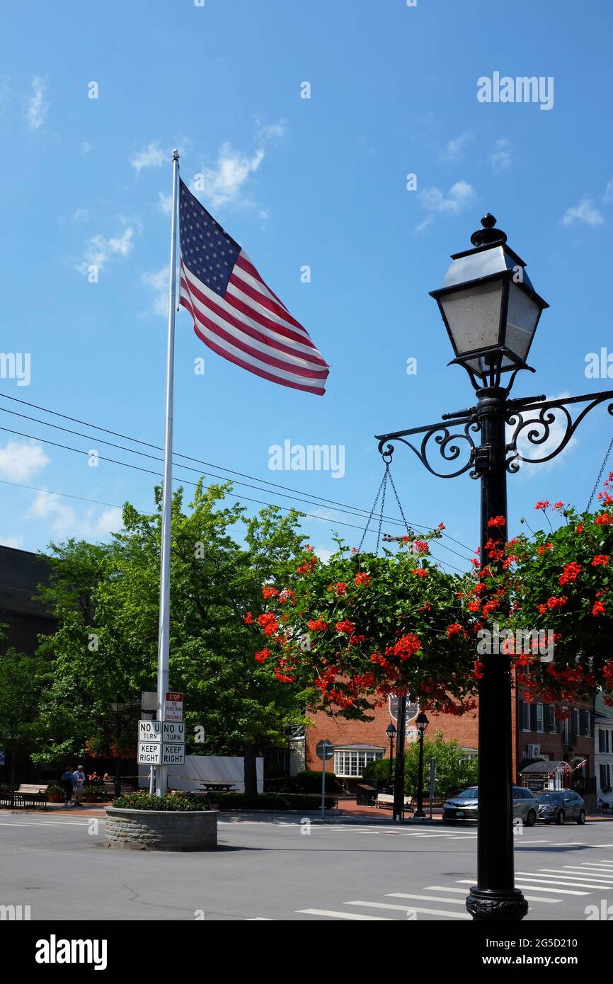 COOPERSTOWN, NEW YORK - 21. JUNI 2021: Flagge und Laternenpfosten an der Kreuzung von Main Street und Pioneer Street in der Upstate Town und Heimat der Nati Stockfoto
