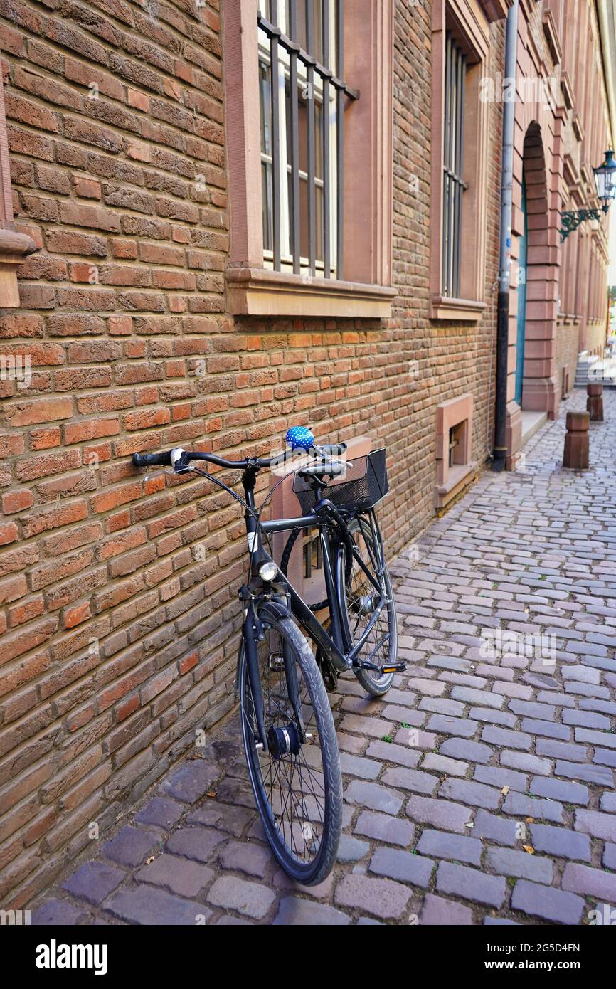Typische Seitenstraße in der historischen Düsseldorfer Altstadt mit Backsteingebäude, Vintage-Fahrrad und Pflastersteinpflaster. Stockfoto