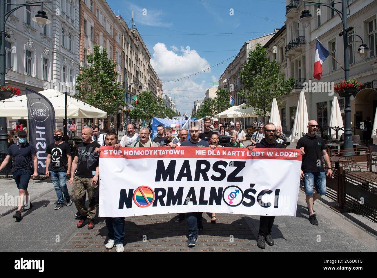 Warschau, Polen. Juni 2021. Mitglieder nationalistischer Gruppen halten vor der Parade von Lodz Pride am 26. Juni 2021 in Lodz, Polen, ein Transparent mit der Aufschrift „Normalitätsmarsch“ als Gegendemonstration ab. Ein paar Dutzend Menschen aus verschiedenen nationalistischen Gruppen marschierten in einer Gegendemonstration mit dem Titel „„Normalitätsmarsch““ durch die Stadt, um sich der Pride-Parade zu widersetzen, die am selben Tag in Lodz stattfindet. Quelle: Aleksander Kalka/ZUMA Wire/Alamy Live News Stockfoto