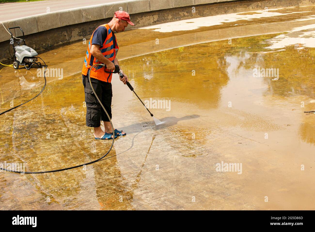 Dnepropetrovsk, Ukraine - 06.25.2021: Vorbeugende Reinigung von Stadtbrunnen im Sommer. Arbeiter säubern den angesammelten Schmutz. Stockfoto