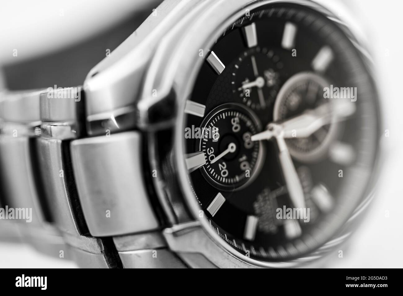 Monochromes Schwarz-Weiß-Nahaufnahme eines Citizen Eco Drive solarbetriebenen Titan-Metall-Männerarmbanduhrs mit Zeigern für Uhrzeiger und Armband Stockfoto