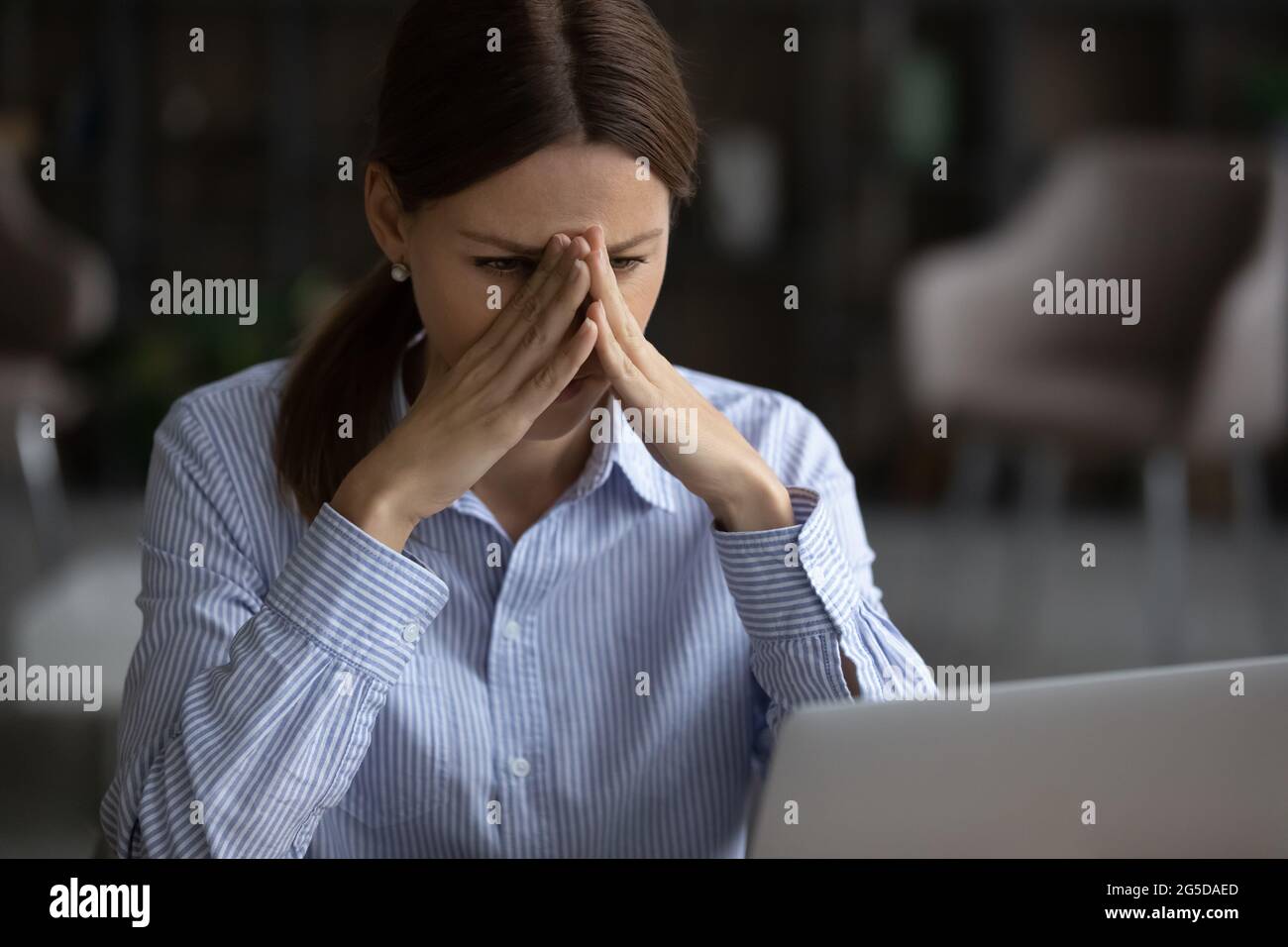 Frustrierte, unglückliche junge Frau, die E-Mails mit schlechten Nachrichten las. Stockfoto