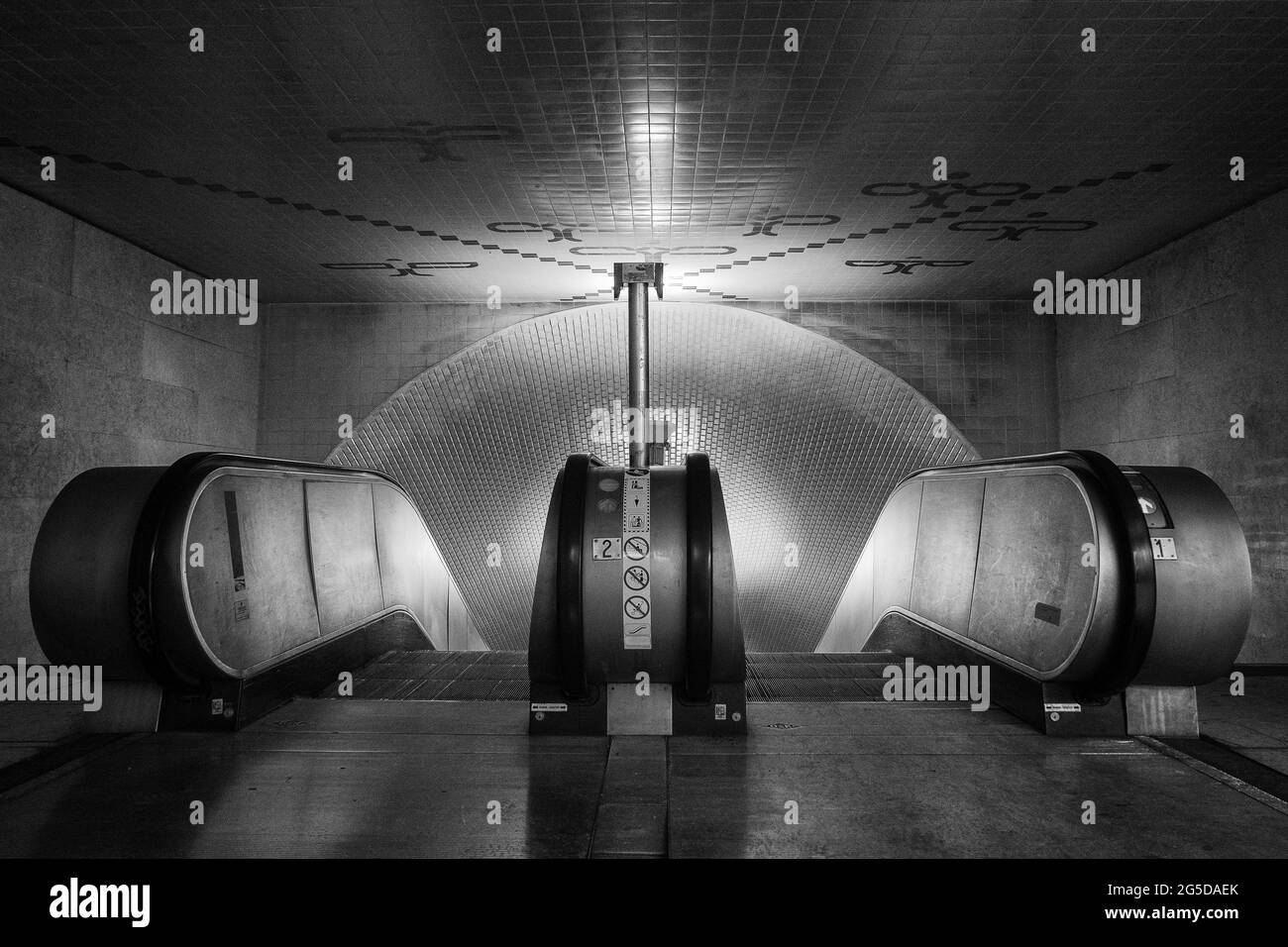 Graustufenaufnahme von Rolltreppen in der U-Bahn-Station in Lissabon, Portugal Stockfoto