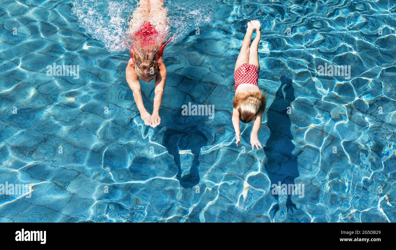 Glückliche Familie im Pool. Kind mit junger Frau schwimmen, tauchen im Pool mit Spaß - springen tief unter Wasser. Gesunde Lebensweise, Menschen Wassersport ein Stockfoto