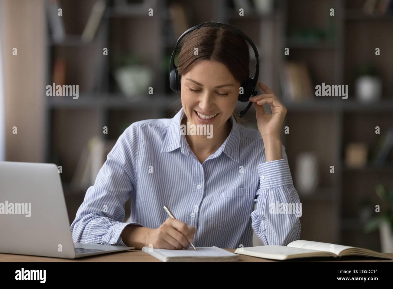 Lächelnde junge Geschäftsfrau, die auf Online-Kursen studiert. Stockfoto