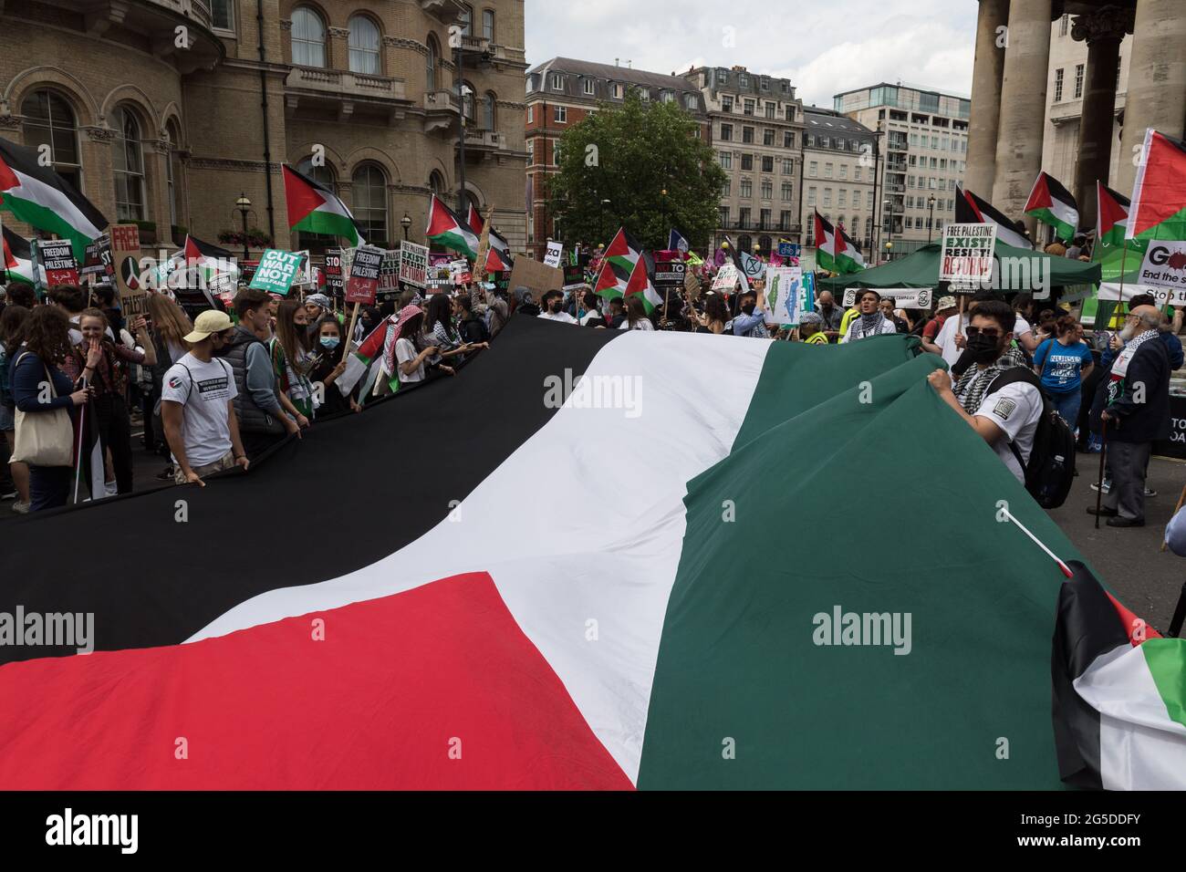 London, Großbritannien. Juni 2021. Die Demonstranten halten eine palästinensische Flagge, während sie sich vor dem BBC Broadcasting House vor der Volksversammlung gegen die nationale Austeritätsdemonstration versammeln und durch das Zentrum Londons marschieren. Demonstranten verschiedener Organisationen protestieren gegen den Umgang der Regierung mit der Coronavirus-Pandemie und fordern die Renationalisierung von Schlüsselindustrien, die Bekämpfung des institutionellen Rassismus und Maßnahmen zur Bekämpfung der Klimanotlage. Quelle: Wiktor Szymanowicz/Alamy Live News Stockfoto