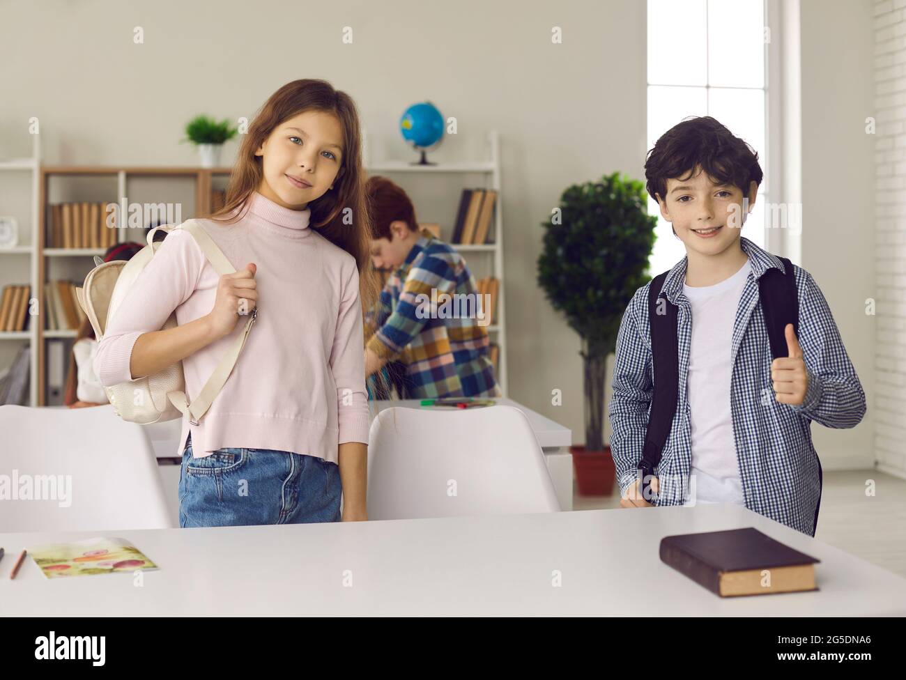 Schüler der Grundschule stehen am Schreibtisch im modernen Klassenzimmer Stockfoto