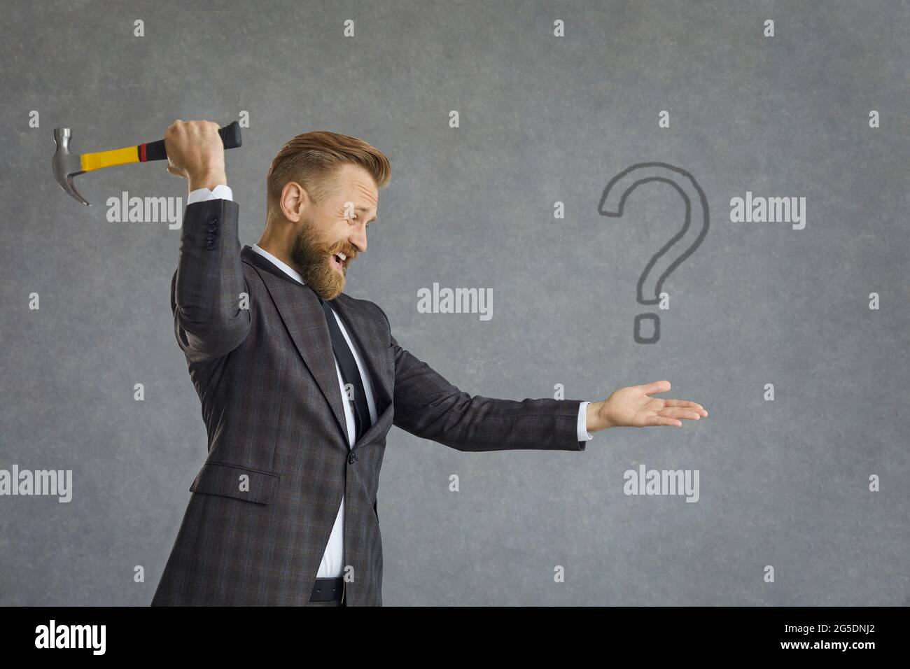 Ein Geschäftsmann, der nach Antworten auf Fragen sucht, möchte ein Fragezeichen mit Hammer abstürzen Stockfoto