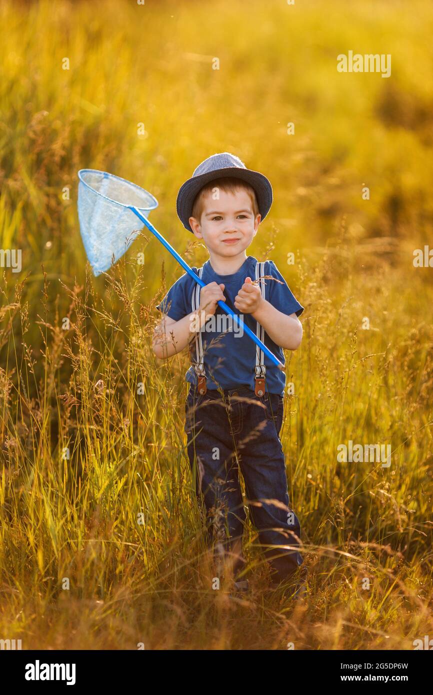 Porträt eines kleinen glücklichen Jungen im Hut mit Schmetterlingsnetz Stockfoto