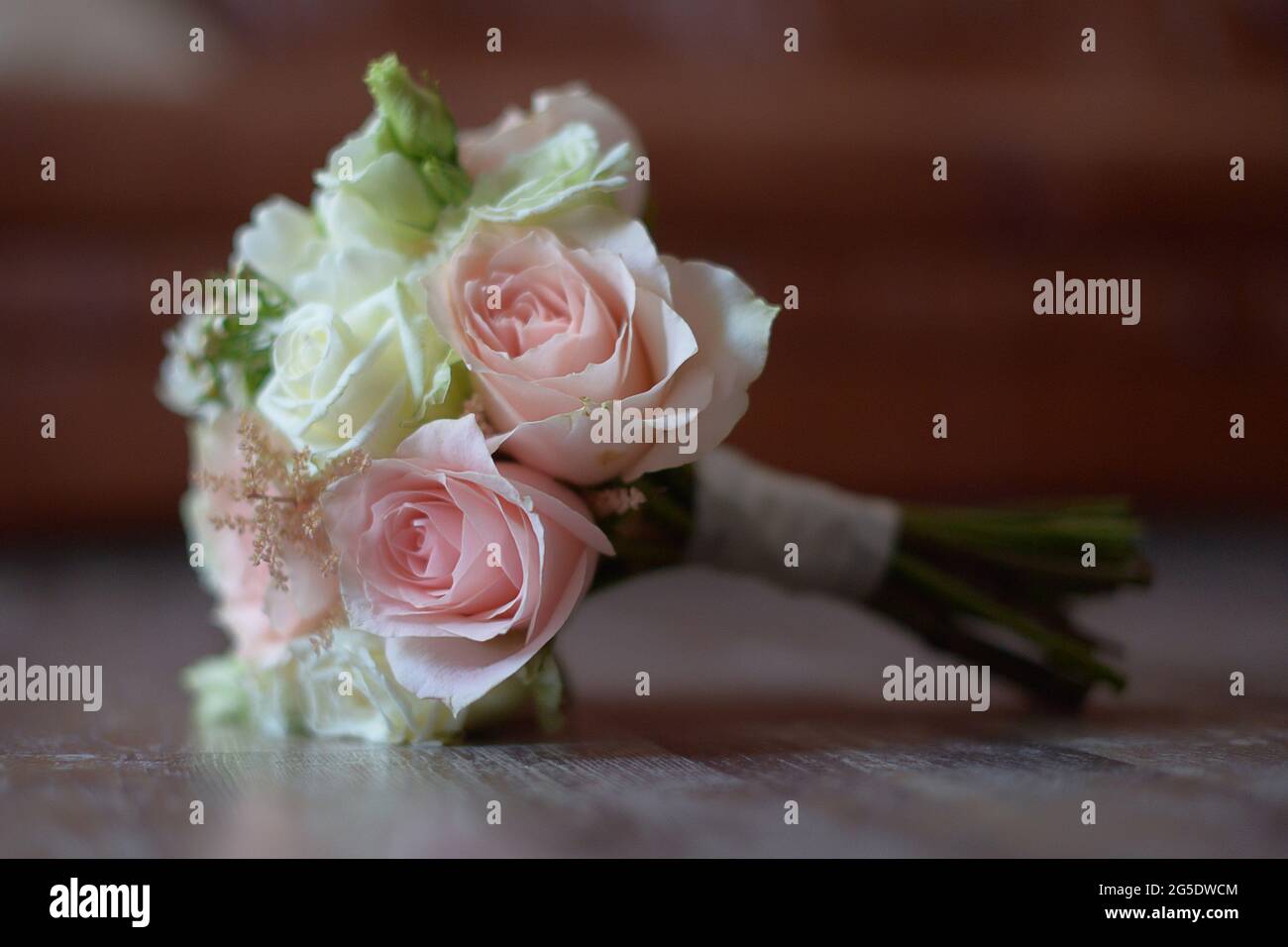 Brautstrauß mit selektivem Fokus auf pastellrosa und weißen Rosen vor unscharfem, weichem Hintergrund, wunderschönes Blumenmuster für die Braut Stockfoto