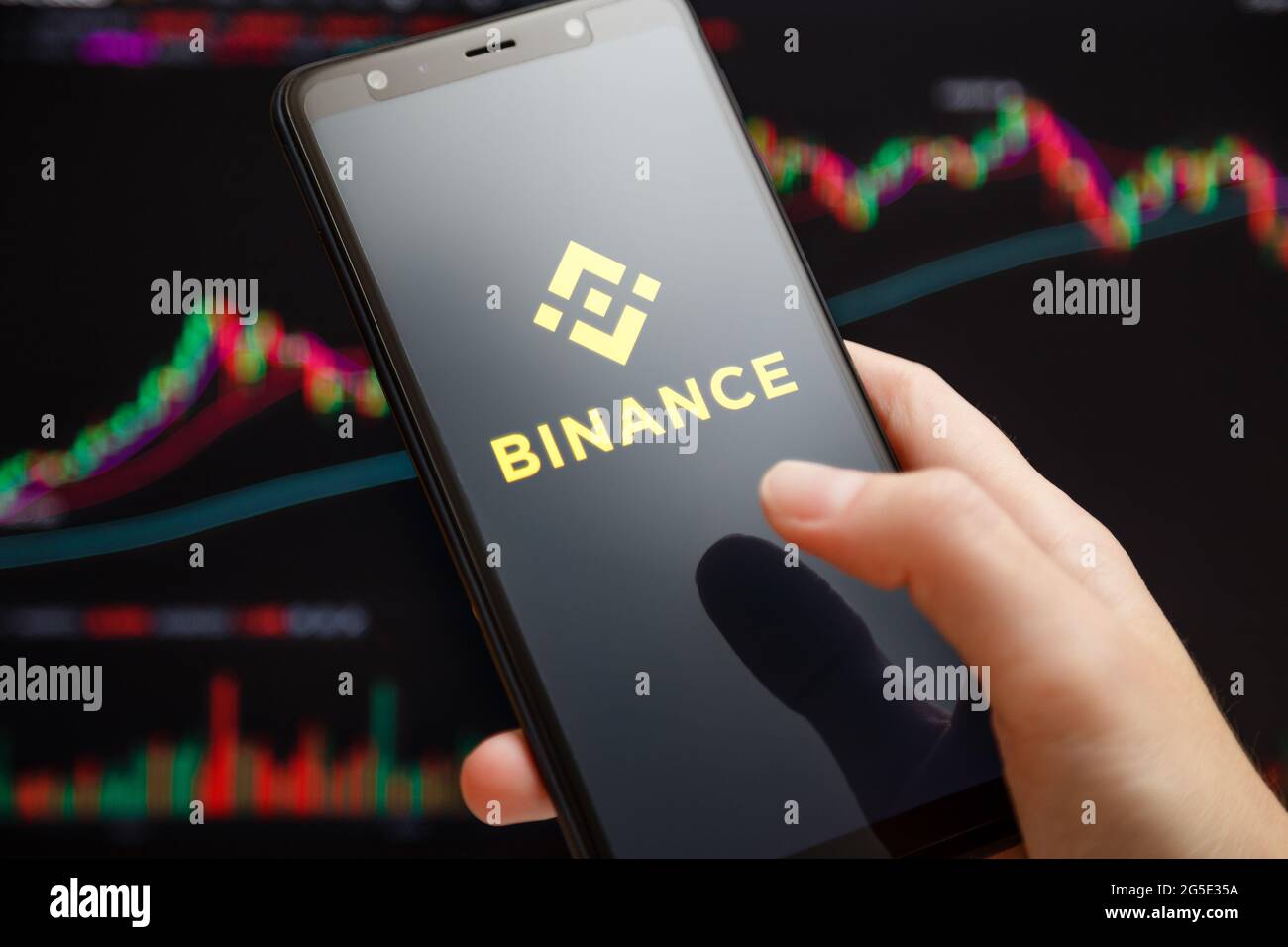 Ukraine, Odessa - 1. Juni 2021: Nahaufnahme des Smartphone mit der mobilen Binance-App, die auf dem Bildschirm läuft, mit einem Trading-Diagramm im Hintergrund Stockfoto