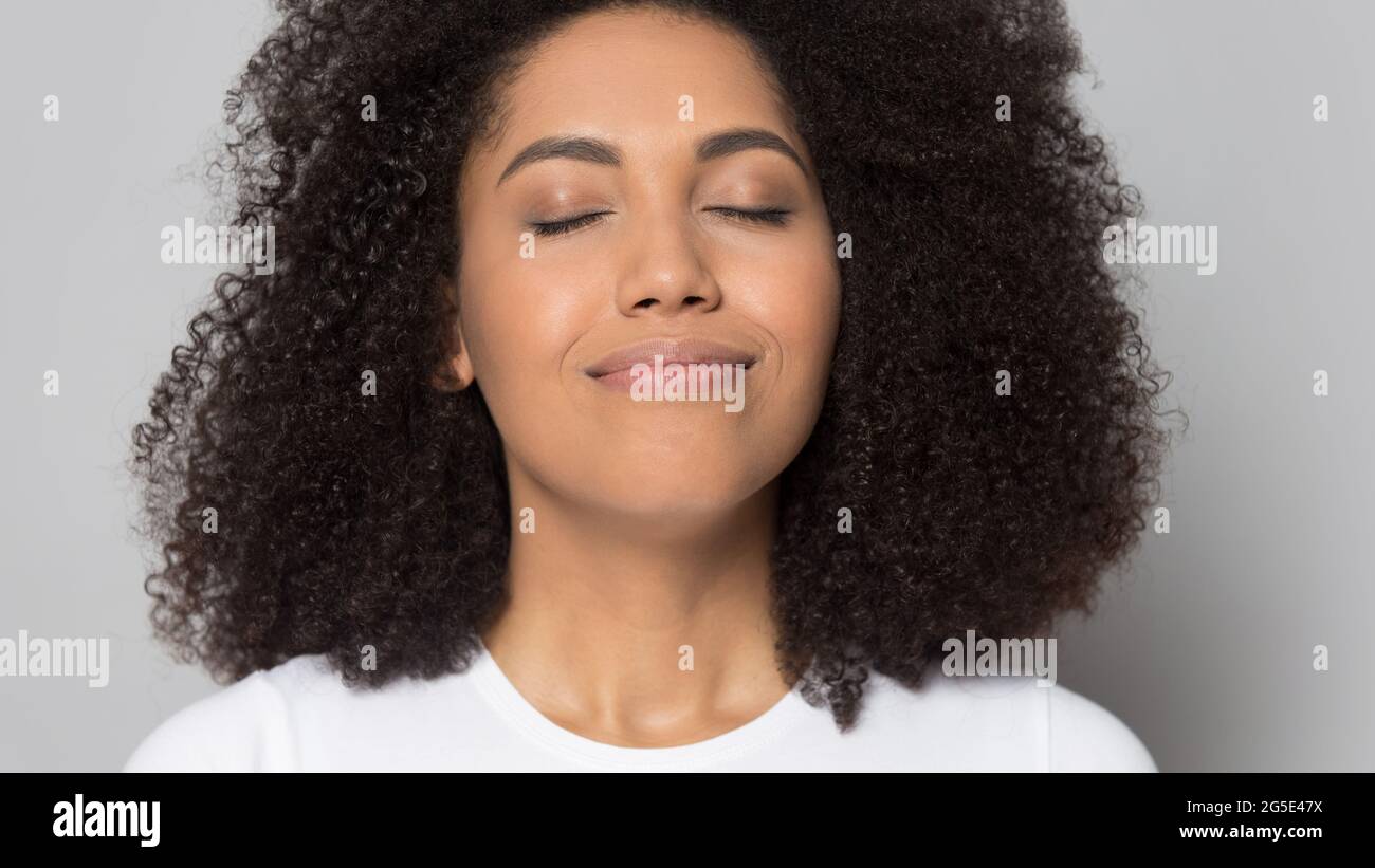 Glückliche afroamerikanische Frau riecht gutes Aroma Stockfoto
