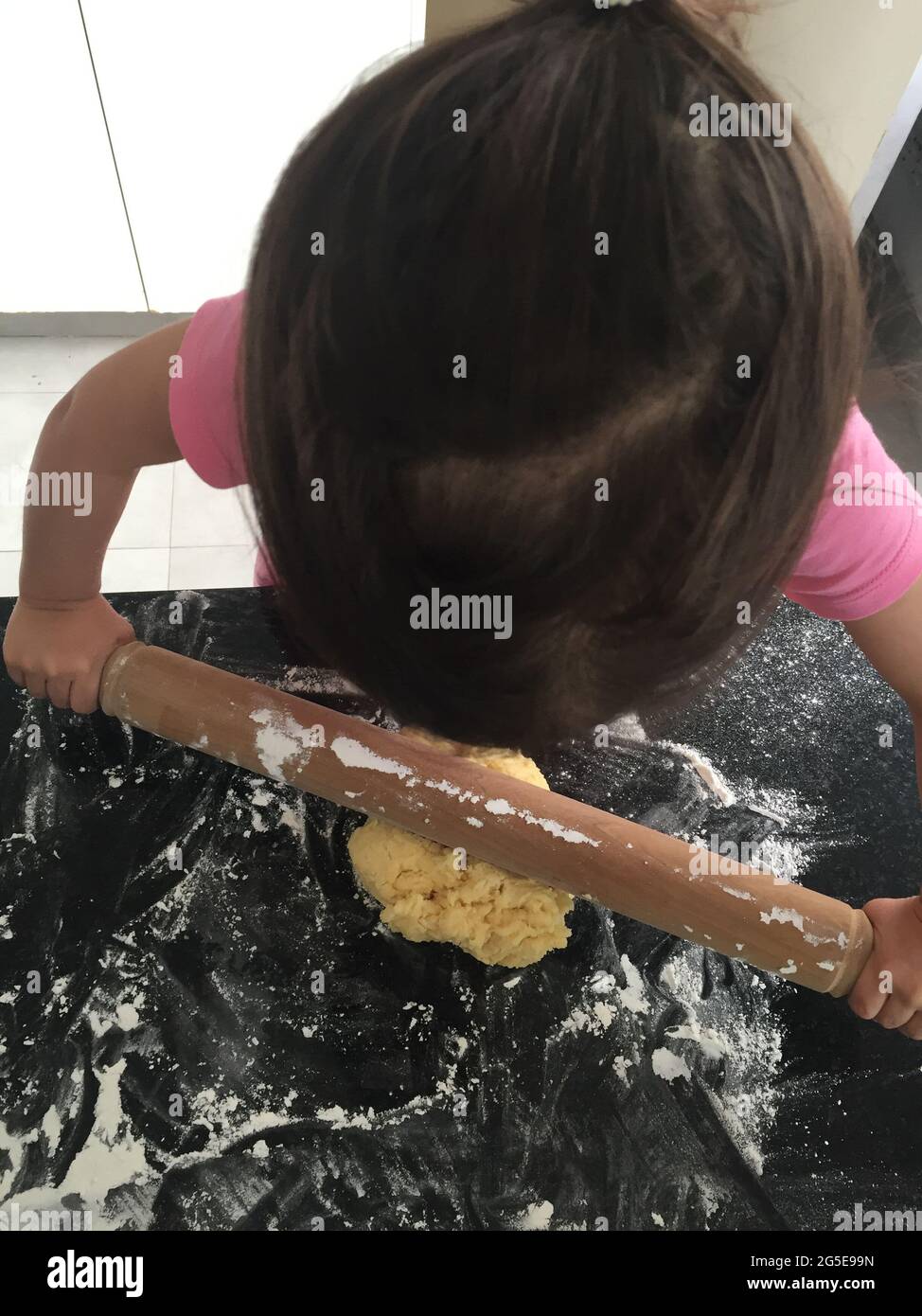 Kleines Mädchen, das Kekse kocht Stockfoto