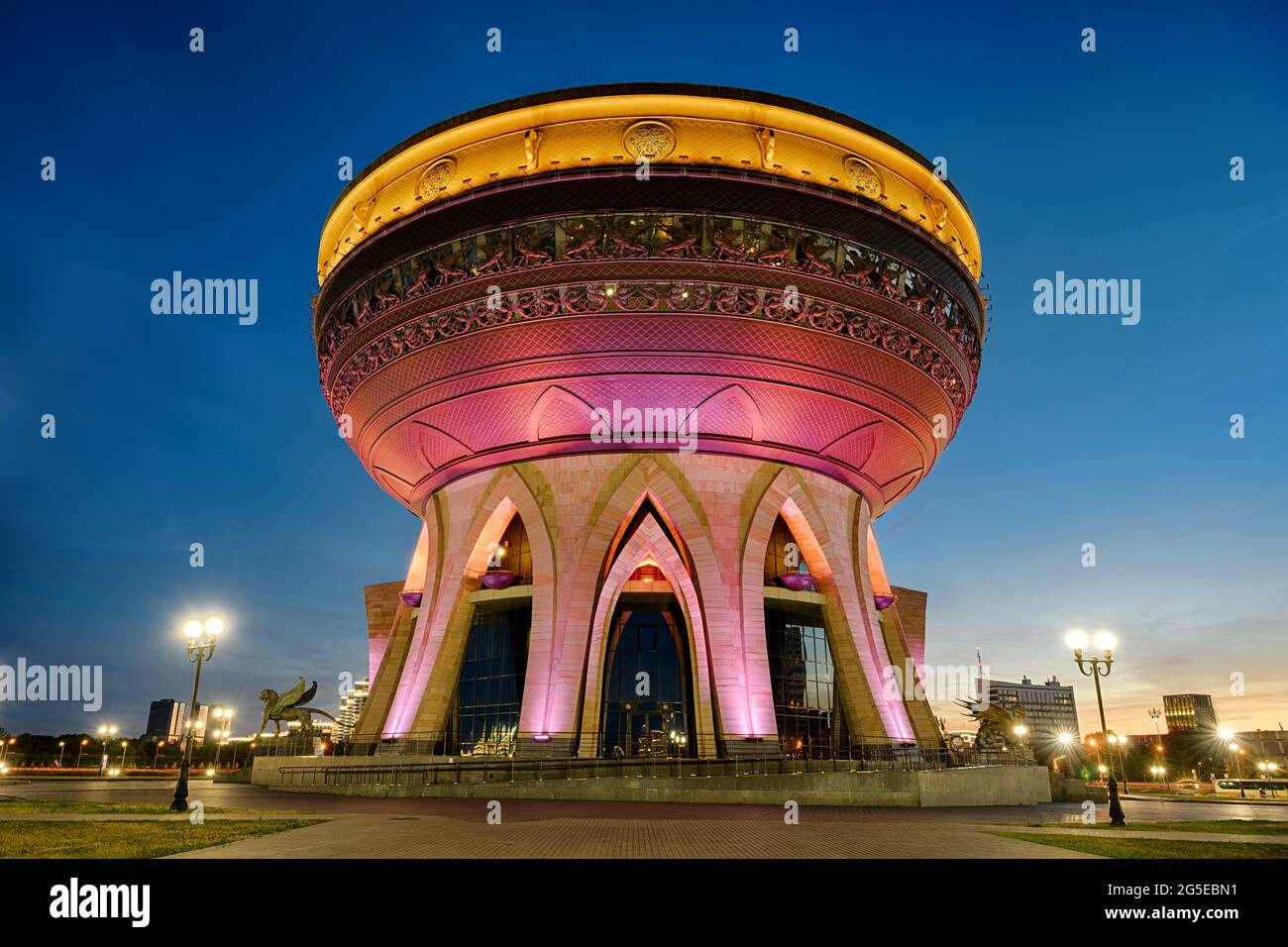 Kasan Wedding Palace (Family Center) in der Nacht in Kasan, Tatarstan, Russland. Es ist das Wahrzeichen von Kazan. Ungewöhnliches Gebäude mit Farbbeleuchtung in der Dämmerung, Tour Stockfoto