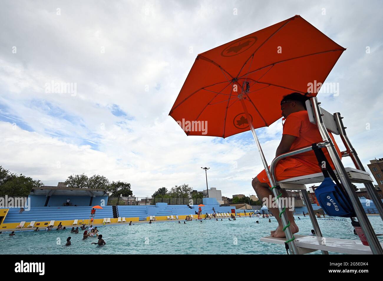 New York, USA. Juni 2021. Ein Rettungsschwimmer der Stadt blickt über die Badegäste im Kosciuszko-Pool, während New York City am 26. Juni 2021 seine öffentlichen Freibäder im Stadtteil Brooklyn von New York City, NY, wieder eröffnet. 48 der Außenpools von New York City werden in allen fünf Stadtbezirken wieder geöffnet, von 11 bis 15 Uhr geöffnet und für eine Stunde zum Reinigen geschlossen. Die Öffnungszeiten sind von 16 bis 19 Uhr. Besucher des Pools müssen Gesichtsmasken tragen, es sei denn, sie befinden sich im Wasser. (Foto von Anthony Behar/Sipa USA) Quelle: SIPA USA/Alamy Live News Stockfoto