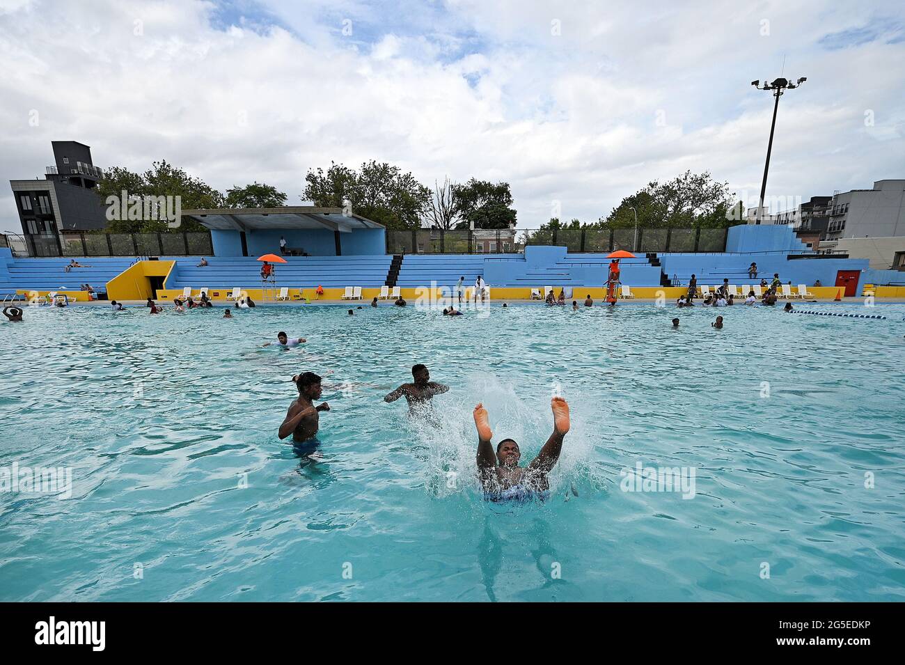 New York, USA. Juni 2021. Ein kleiner Junge stürzt sich rückwärts in den Kosciuszko-Pool, als New York City am 26. Juni 2021 seine öffentlichen Freibäder im Stadtteil Brooklyn von New York City, NY, wieder eröffnet. 48 der Außenpools von New York City werden in allen fünf Stadtbezirken wieder geöffnet, von 11 bis 15 Uhr geöffnet und für eine Stunde zum Reinigen geschlossen. Die Öffnungszeiten sind von 16 bis 19 Uhr. Besucher des Pools müssen Gesichtsmasken tragen, es sei denn, sie befinden sich im Wasser. (Foto von Anthony Behar/Sipa USA) Quelle: SIPA USA/Alamy Live News Stockfoto