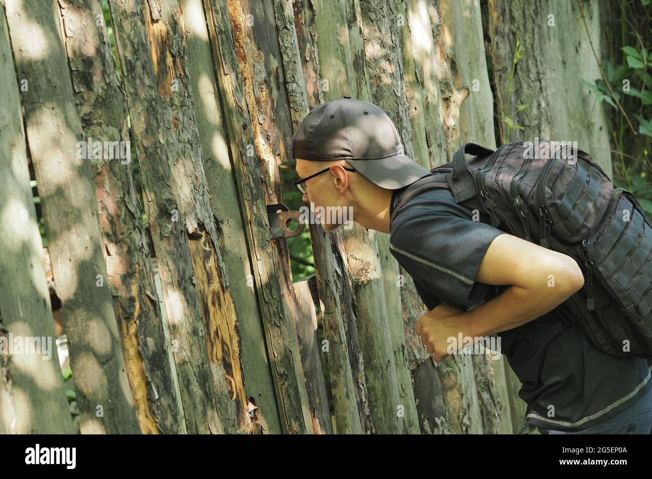 Holzzaun. Ein junger Mann steht an einem alten Holzzaun. Stockfoto