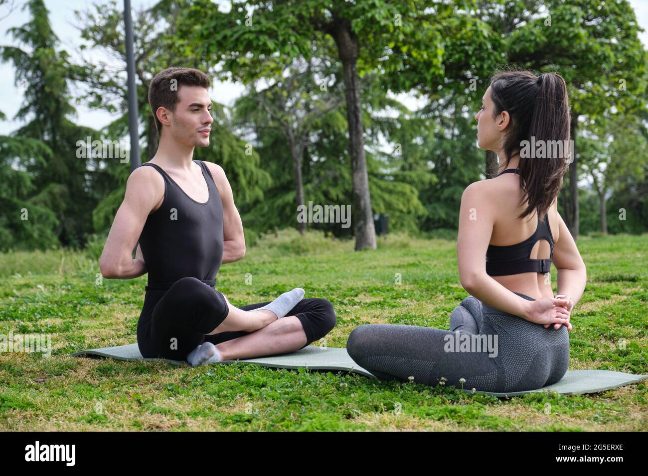 Meditationslehrer, der seinem Schüler lehrt, wie man atmet und meditiert. Die Hände werden hinter dem Rücken und im Kreuzbein zusammengelegt. Stockfoto