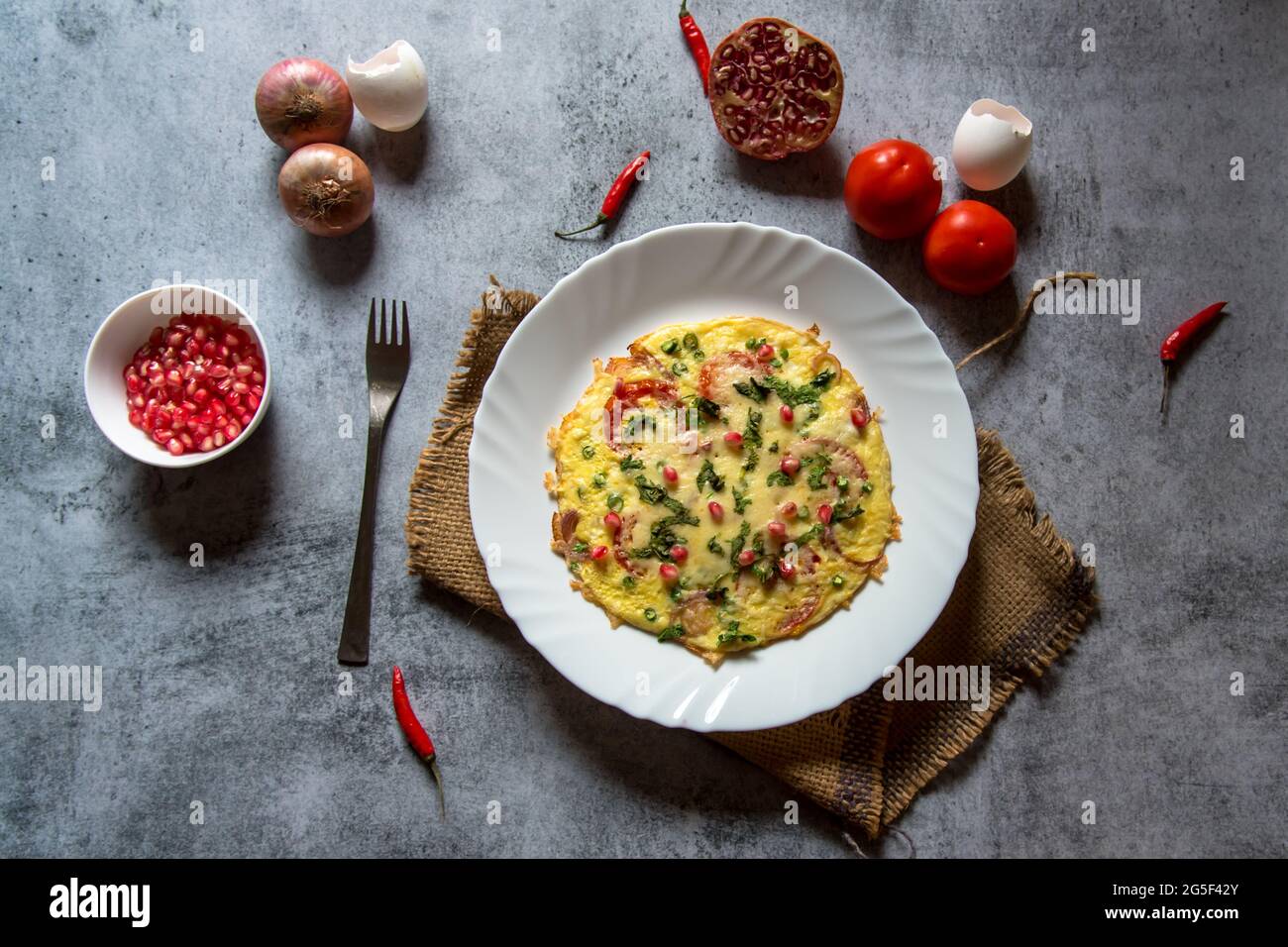 Käse-Tomatenomelett oder spanisches Omelett, zubereitet mit einer Eierbasis mit zusätzlichen Zutaten aus Käse, Pfeffer, Zwiebeln, Knoblauch und Tomaten. Stockfoto