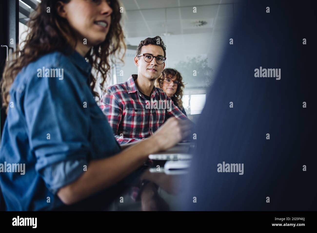 Geschäftsmann, der während des Meetings am Konferenztisch sitzt. Männliche Führungskraft, die während der Besprechung auf die Diskussion achtet. Stockfoto