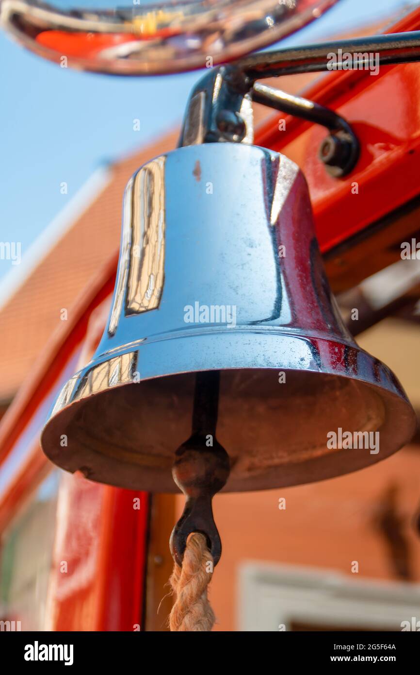 Alarmglocke auf Vintage-Feuerwehrauto als frühe Form eines speziellen Signals mit Reflexionen auf der polierten Glocke Stockfoto