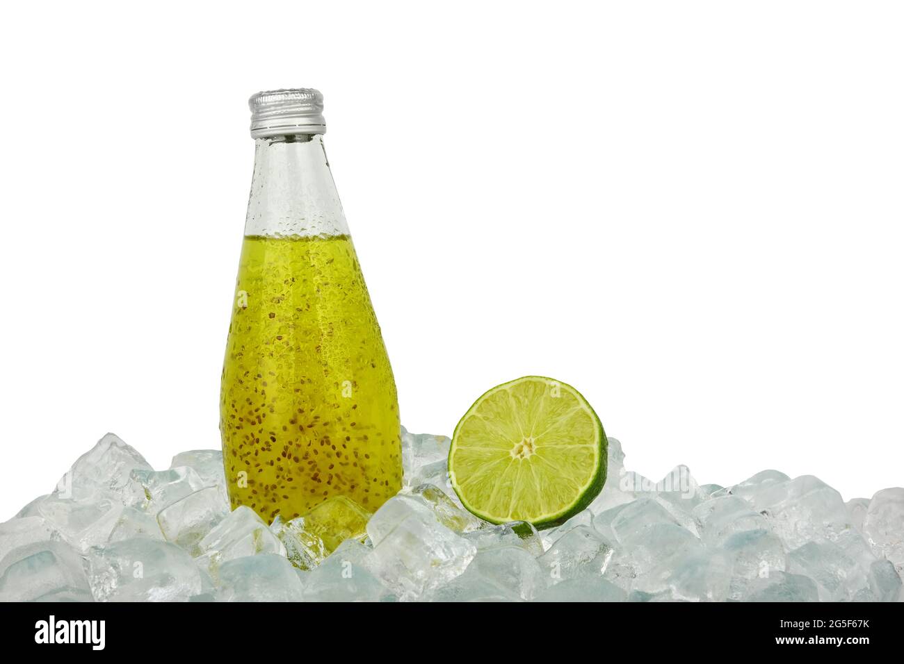 Nahaufnahme einer Glasflasche kaltes grünes Cocktailgetränk mit Chiasamen und halbgeschnittener Limette auf Eiswürfeln isoliert auf weißem Hintergrund, schräg verwinkelte Seite Stockfoto