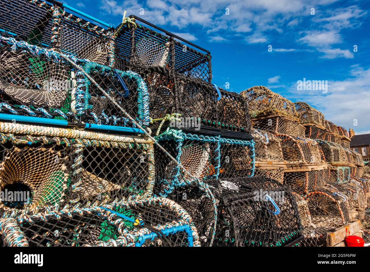 In Schottland stapelten sich auf einer Hafenseite Fischfangkreale Stockfoto