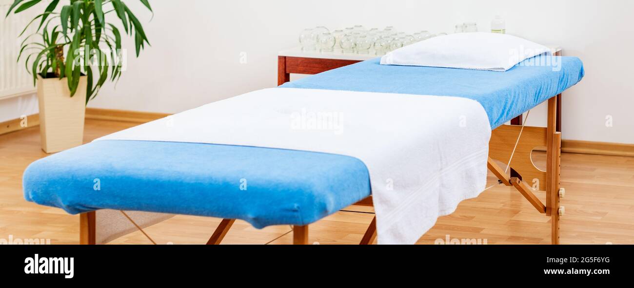 Innenraum eines medizinischen Behandlungsraums mit tragbarem Untersuchungstisch. Vakuum Schröpfen, Massage oder Physiotherapie Hintergrund. Stockfoto