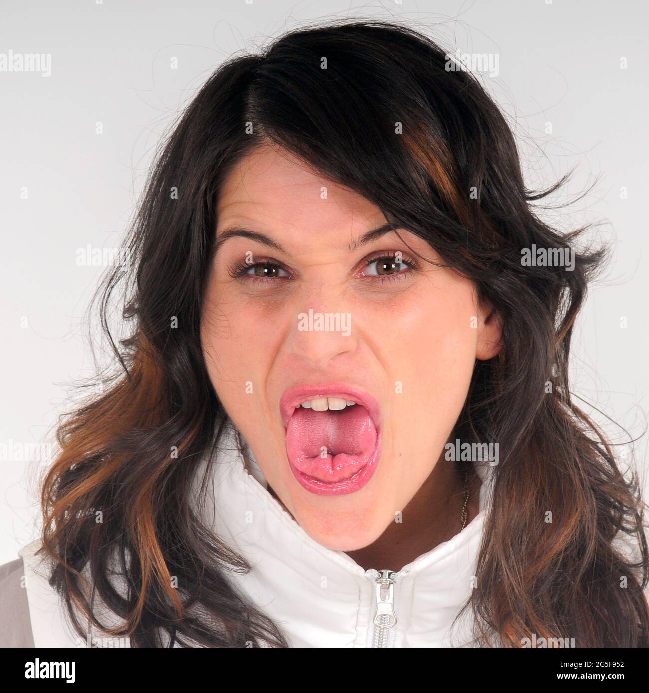 Kleeblatt oder nach oben gerollte Zunge. Frau streckte ihre Zunge aus ihrem Mund, wobei die Seiten ihrer Zunge nach oben gerollt waren. Die Zunge, ein Komplex Stockfoto
