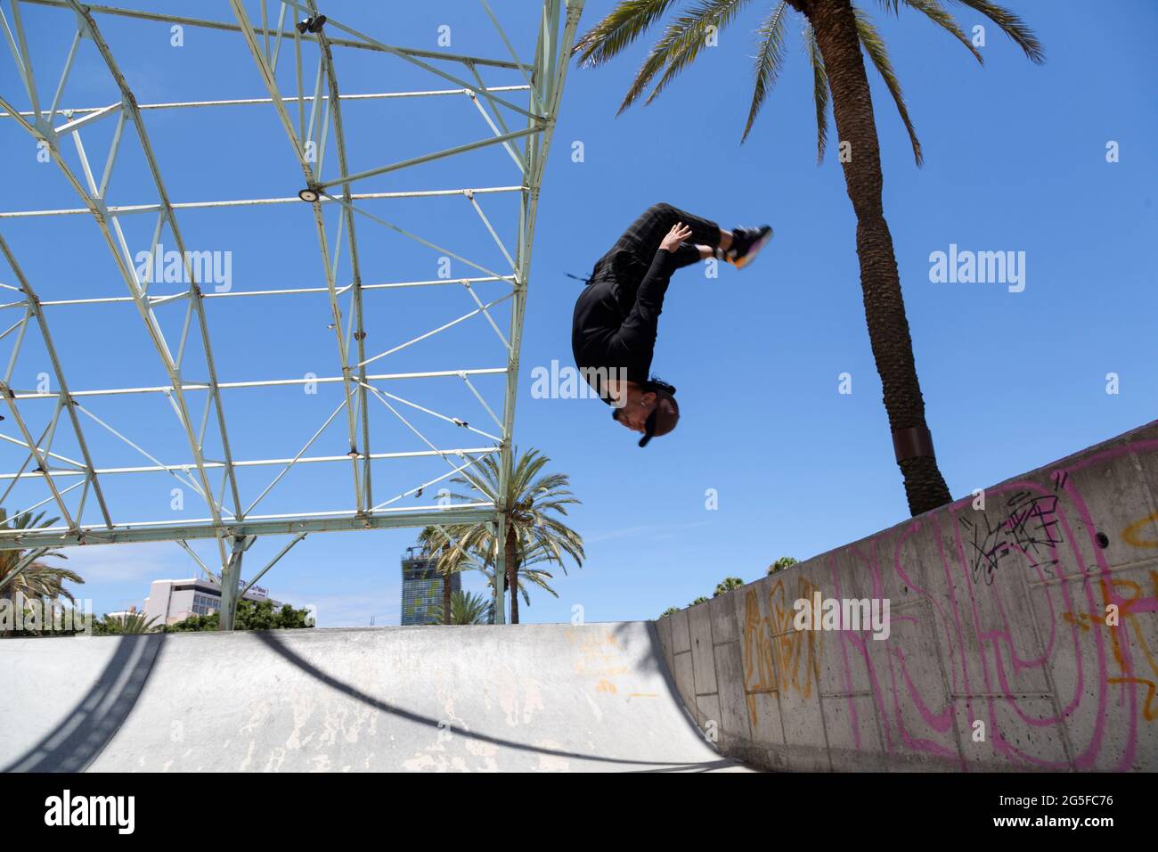 Junger lateiner, der im Skatepark akrobatische Sprünge macht. Stockfoto