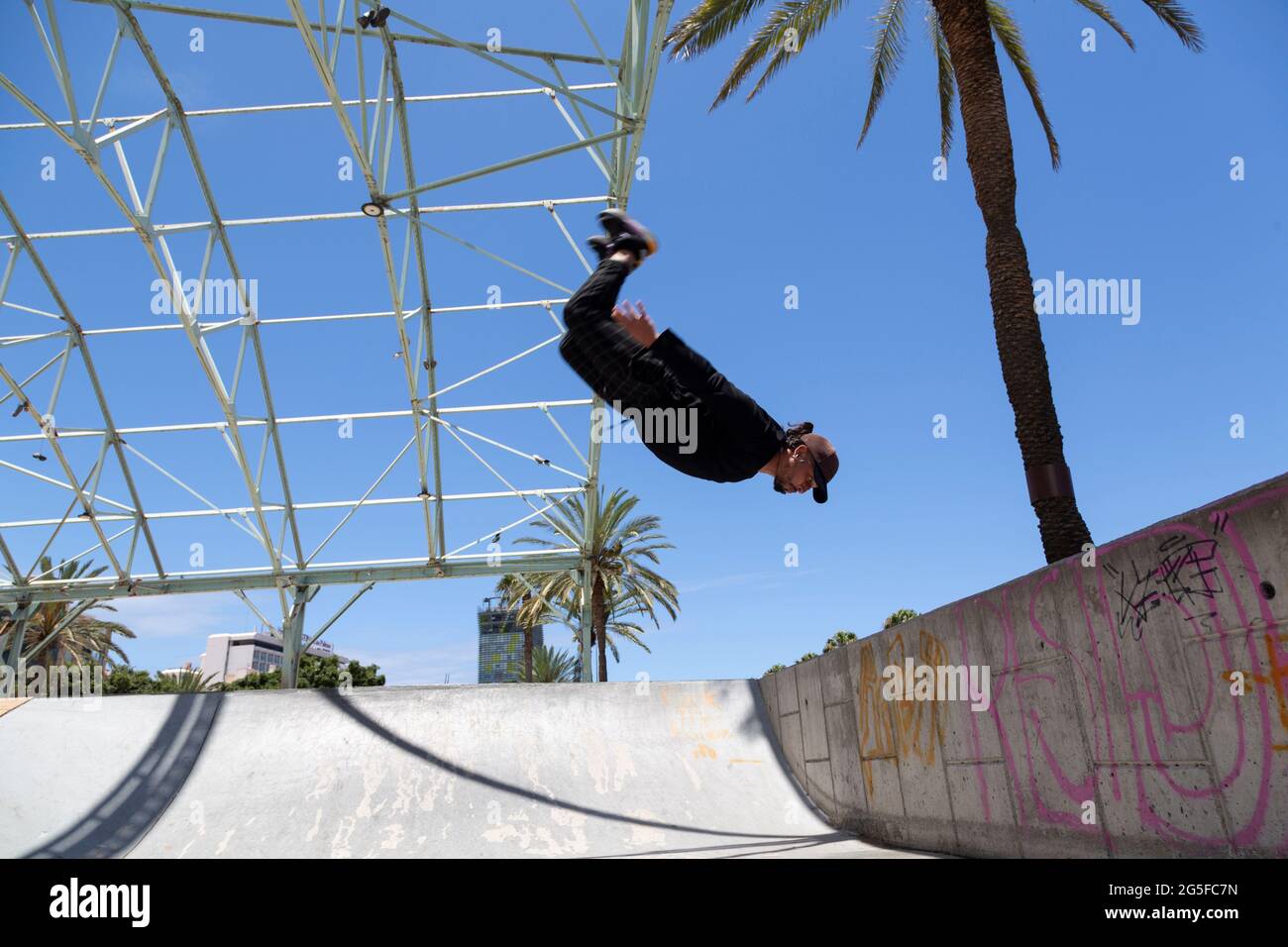 Junger lateiner, der im Skatepark akrobatische Sprünge macht. Stockfoto