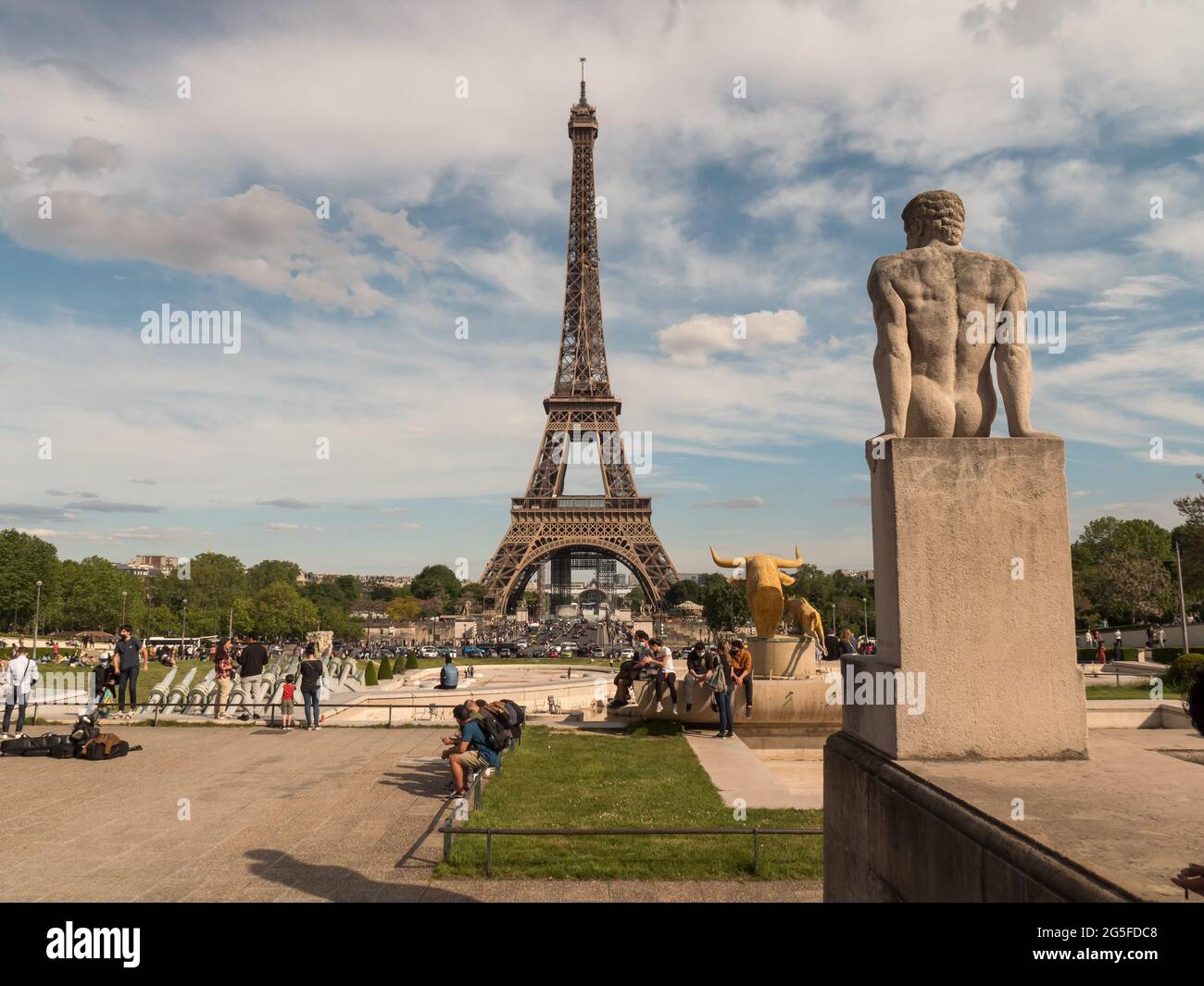 Paris, FRANKREICH - 2021. Mai: Der Eiffelturm, das Symbol von Paris, Vorderansicht, Touristen entspannen sich vor dem Hintergrund eines nicht funktionierenden Springbrunnens Stockfoto