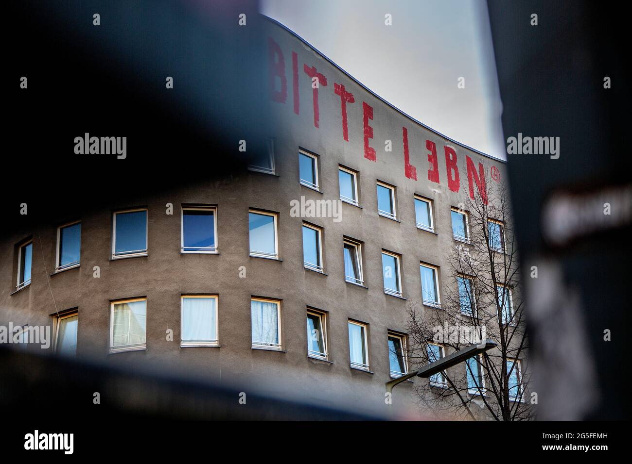 Eine Graffiti auf einem alten Art-Deco-Gebäude in einem Berliner Stadtteil, das für die Gentrifizierung bestimmt ist, lautet „Bitte Lebn“, übersetzt mit „Let live“. Stockfoto
