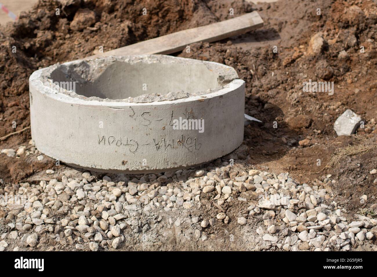Betonring. Ein Brunnen aus Beton im gegrabenen Boden. Bauarbeiten