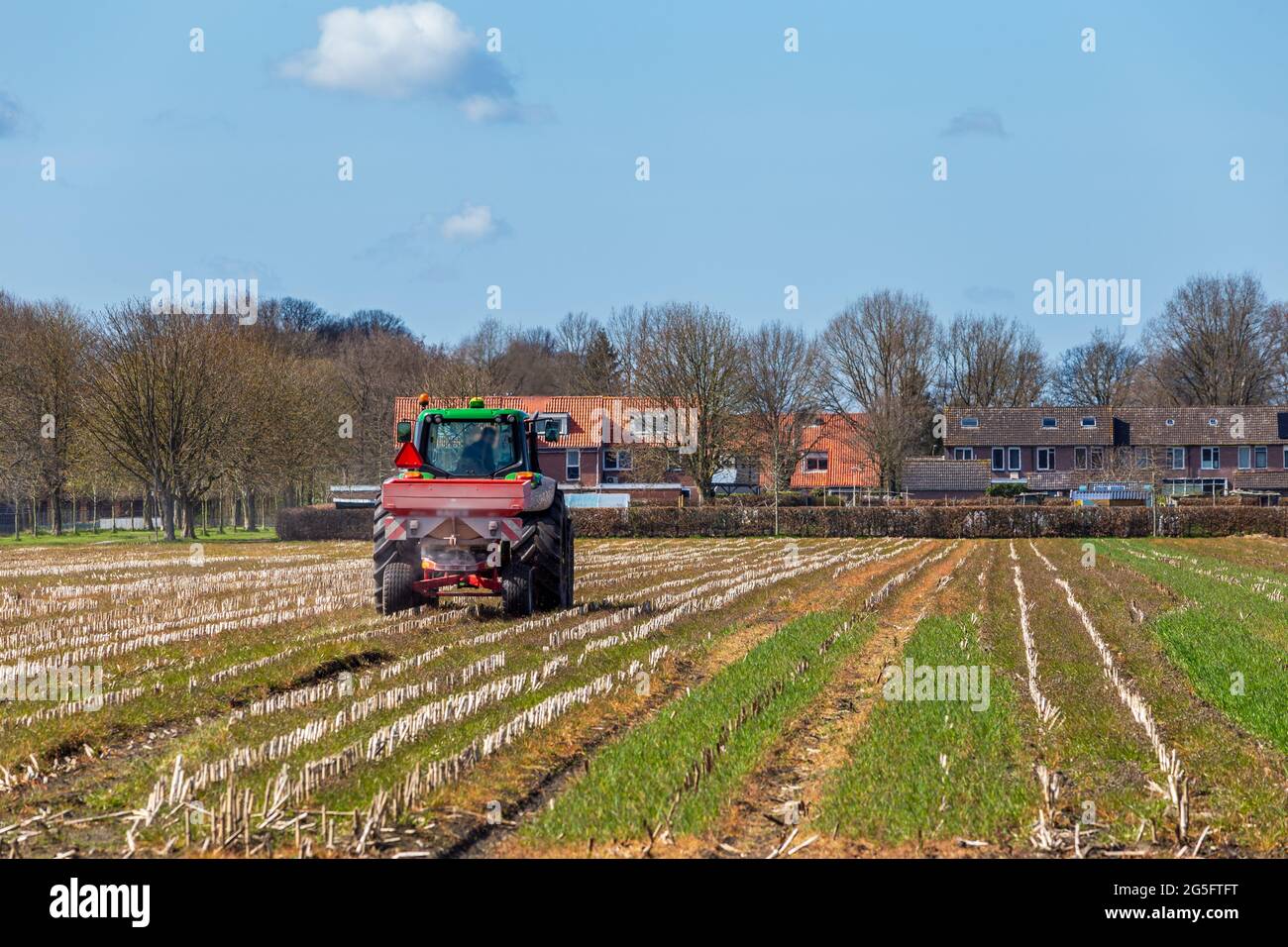 Landschaft mit Landwirt auf Traktor Düngung seines Landes Stockfoto
