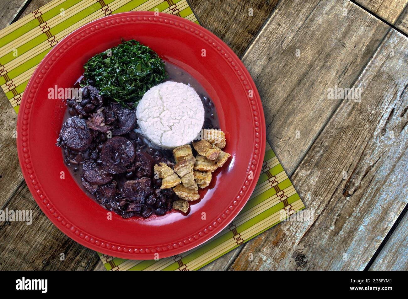 Feijoada komplett mit verschiedenen leckeren Zutaten, typisch brasilianische Küche. Studiofotografie. Stockfoto