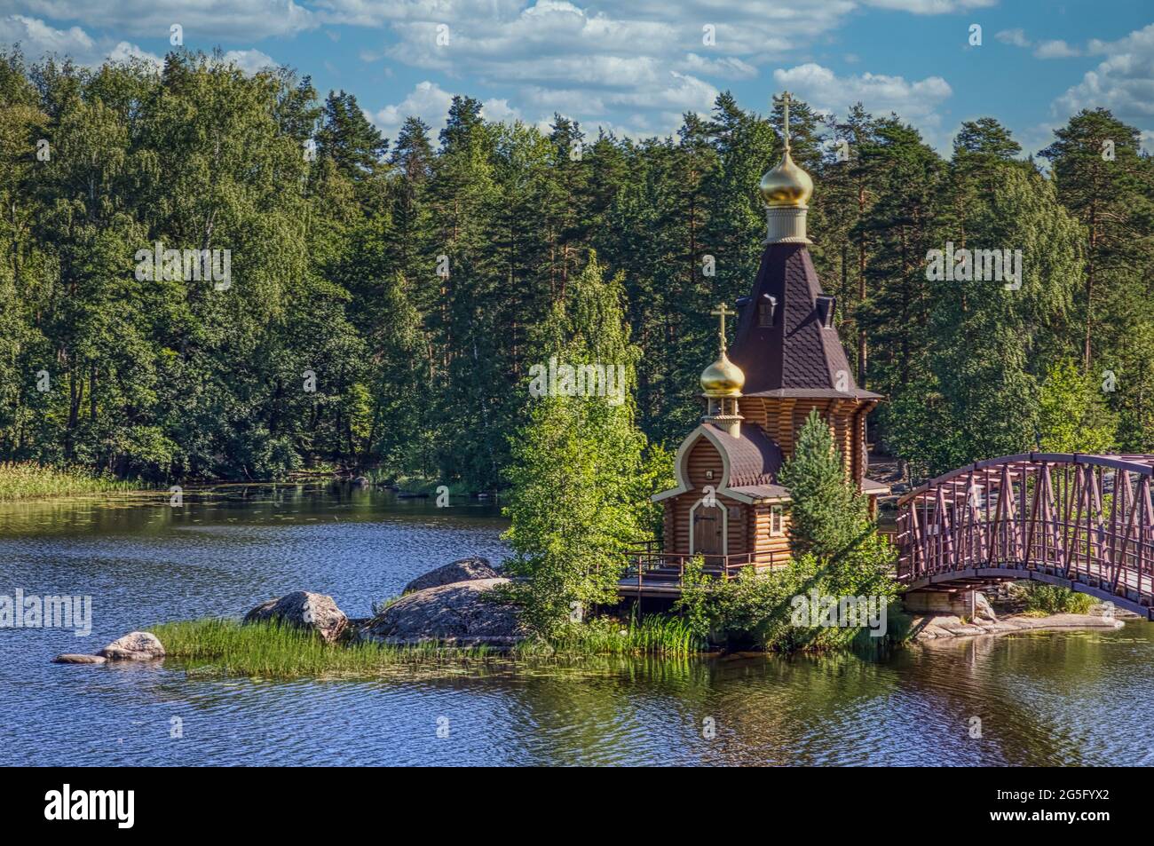 PRIOZERSK, RUSSIA-CIRCA Jun, 2018: Holzkirche von Andrew erstmals am Fluss Vuoksa benannt. Es ist eine kleine Kirche auf der Felsinsel in der Nähe des Dorfes Vasiljevo Stockfoto