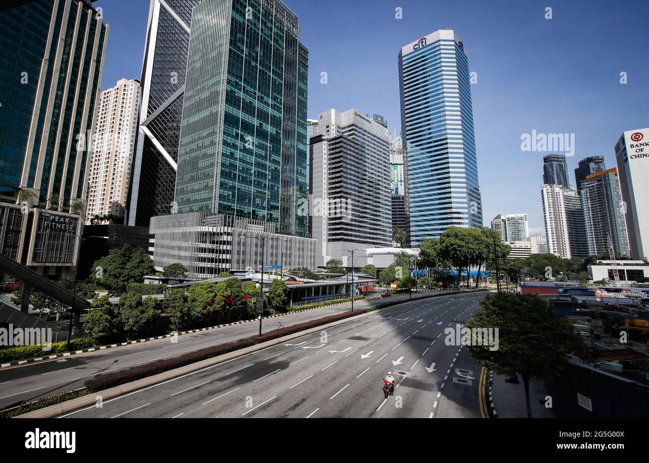 Ein Motorradfahrer fährt auf leeren Straßen in der Innenstadt von Kuala Lumpur. Die malaysische Regierung kündigte an, dass die am Montag fällige, einmonatige Vollsperrung aufgrund der täglich hohen Zahl der gemeldeten Fälle von Coronavirus-Infektionen verlängert wird. (Foto von Wong Fok Loy / SOPA Images/Sipa USA) Stockfoto