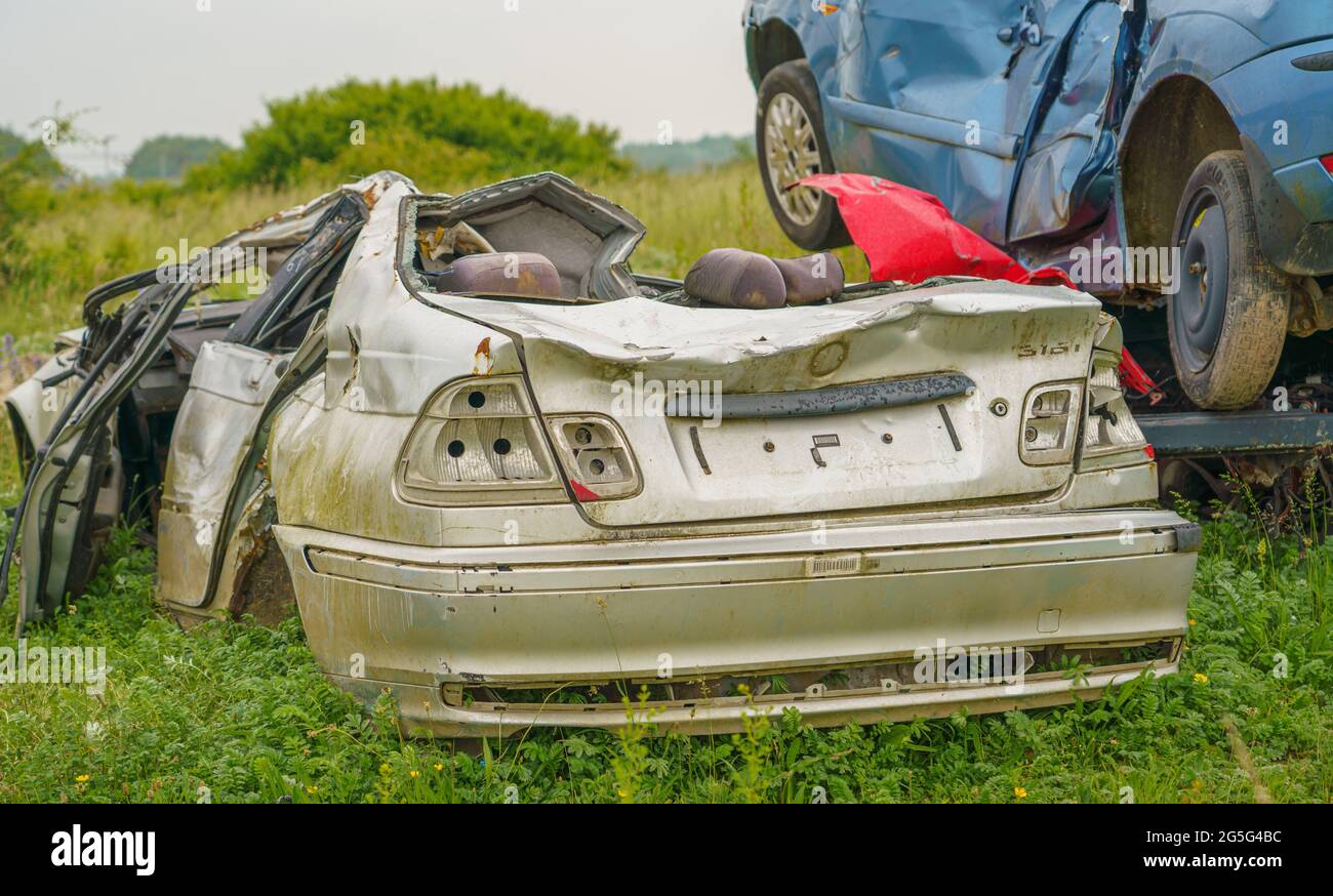 Die zerquetschten Überreste eines Autos, nachdem ein Armeepanzer absichtlich darüber gefahren ist und nur noch Schrott hinterlassen hat Stockfoto
